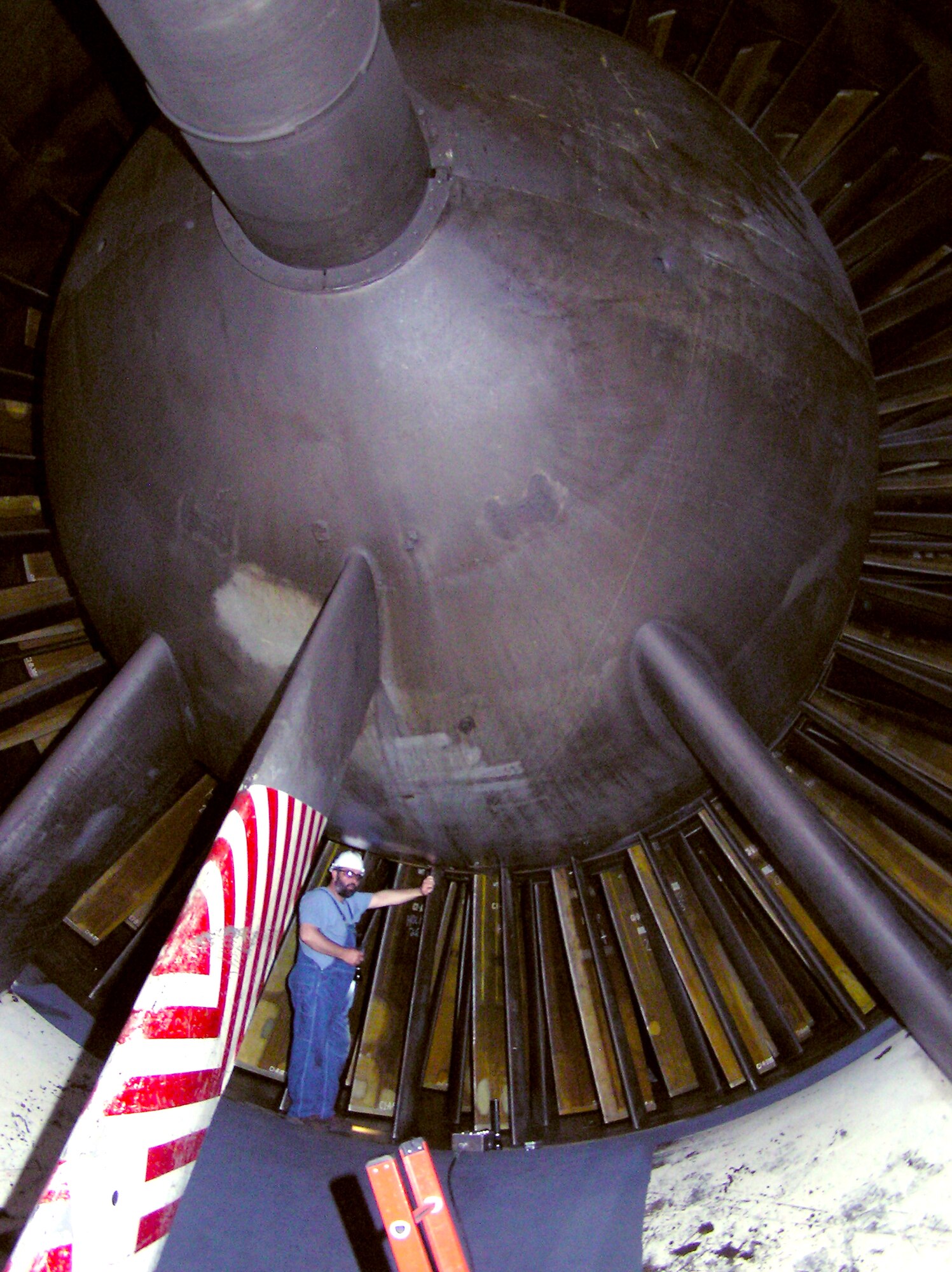 To show its size, an AEDC craftsman stands beside compressor blades in the bell mouth of one of the Propulsion Wind Tunnel facility compressors. The Complex has a Blade Shop that leads repair of the rotor blades and spacers for the compressors in PWT. (Photo provided)