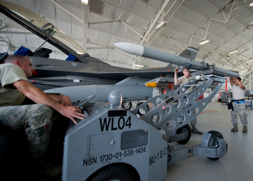 The 96th Aircraft Maintenance Squadron Blue team moves a missile into place on their F-16 Fighting Falcon during the third quarter loadcrew competition Sept. 30 at Eglin Air Force Base, Fla.  The AMU-Red F-15 team won the competition loading three missiles in the quickest time with the fewest discrepancies.  (U. S. Air Force photo/Samuel King Jr.)
