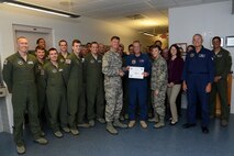 Gene Stamps, center, 47th Student Squadron T-38C Talon simulator instructor, poses with Col. Thomas Shank, 47th Flying Training Wing commander, Chief Master Sgt. Teresa Clapper, 47th FTW command chief, after accepting the “XLer of the Week” award, here, Sep. 30, 2015. The “XLer” is a weekly award chosen by wing leadership and is presented to those who consistently make outstanding contributions to their unit and Laughlin. (U.S. Air Force photo by Airman 1st Class Ariel D. Partlow) (Released)