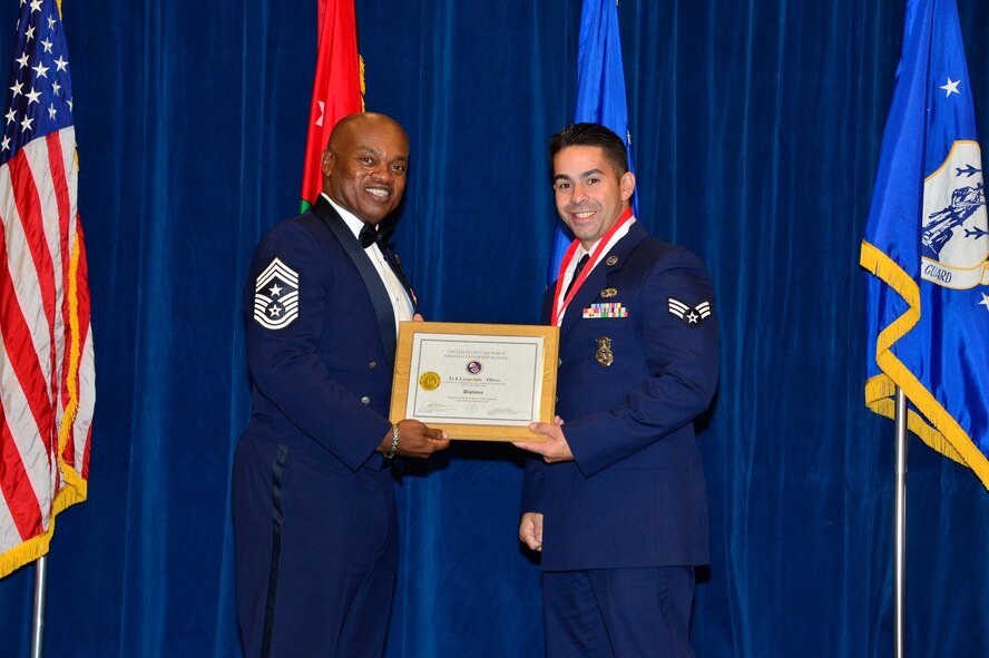 MCGHEE TYSON AIR NATIONAL GUARD BASE, Tenn. - Senior Airman Leopoldo Otero, right, receives the Distinguished Graduate Award for Airman leadership school class 15-8 from  Chief Master Sgt. Anthony Whitehead, command Chief Master Sgt. for the Air National Guard Readiness Center, here, Sept. 29, 2015, at the I. G. Brown Training and Education Center. The distinguished graduate award is presented to students in the top 10 percent of the class. (U.S. Air National Guard photo by Master Sgt. Jerry D. Harlan/Released)