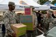 From left, Airmen 1st Class Michael Alexander Brazier and Nenos David, 4th Communications Squadron radio maintenance technicians, and Staff Sgt. Wayne Baxter, 4th Civil Engineer Squadron unit deployment manager, place boxes into a car, Sept. 29, 2015, at Seymour Johnson Air Force Base, North Carolina. More than 45 volunteers came and handed out boxes donated by Feed the Children.   (U.S. Air Force photo/Airman Shawna L. Keyes)  