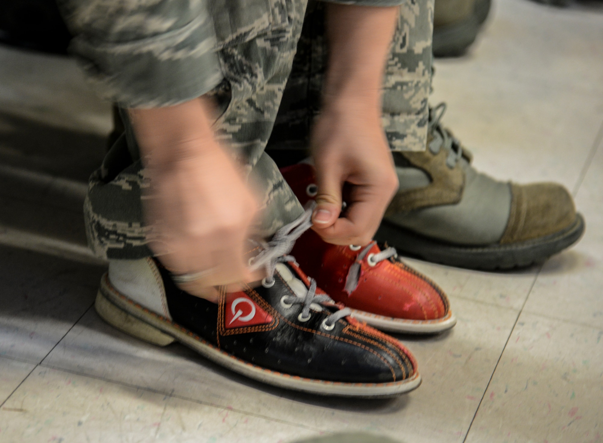 An Airman laces up her bowling shoes prior to her team’s turn to start during a bowling tournament at the MiG Alleys Bowling Center during the Osan Cup at Osan Air Base, Republic of Korea, Sept. 30, 2015. The Osan cup is a sport-oriented, two-day event that puts squadrons and service members against each other in a battle royal to show who has the most skill, strength and knowledge. (U.S. Air Force photo/Tech. Sgt. Travis Edwards) 