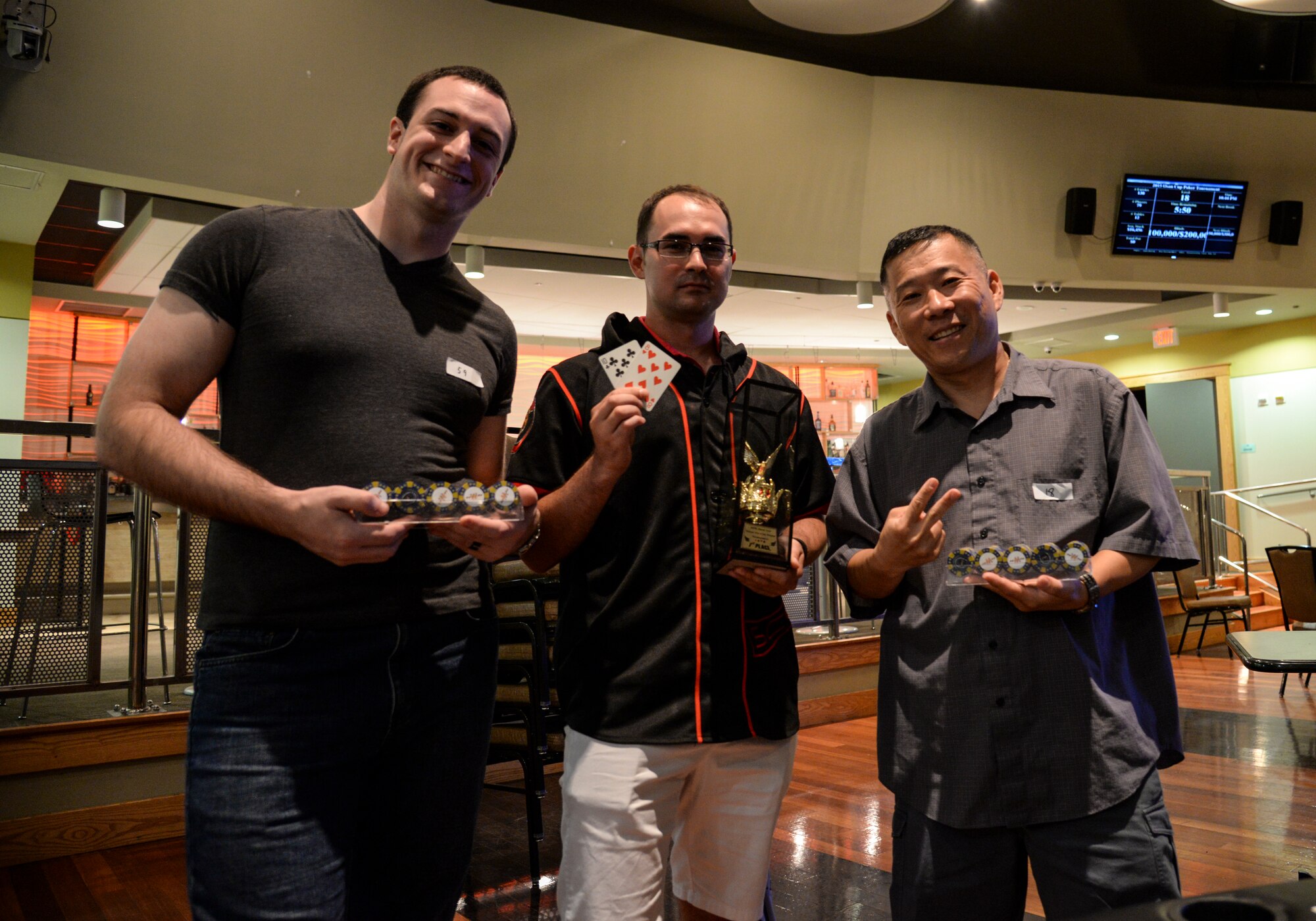 Airman 1st Class Alan Jaensch, 51st Maintenance Group, commanders support staff, Staff Sgt. Scott Moore, 694th Intelligence Support Squadron communications technician and Tech. Sgt. Byung Kim, 51st Fighter Wing Inspector General staff member, pose for an after-tournament photo where Moore took first place in the Texas Hold ’em tournament in the Osan Cup at Osan Air Base, Republic of Korea, Sept. 29, 2015. The poker tournament took nearly five hours to complete and had approximately 130 players. The Osan cup is a sport-oriented, two-day event that puts squadrons and service members against each other in a battle royal to show who has the most skill, strength and knowledge. (U.S. Air Force photo/Tech. Sgt. Travis Edwards)