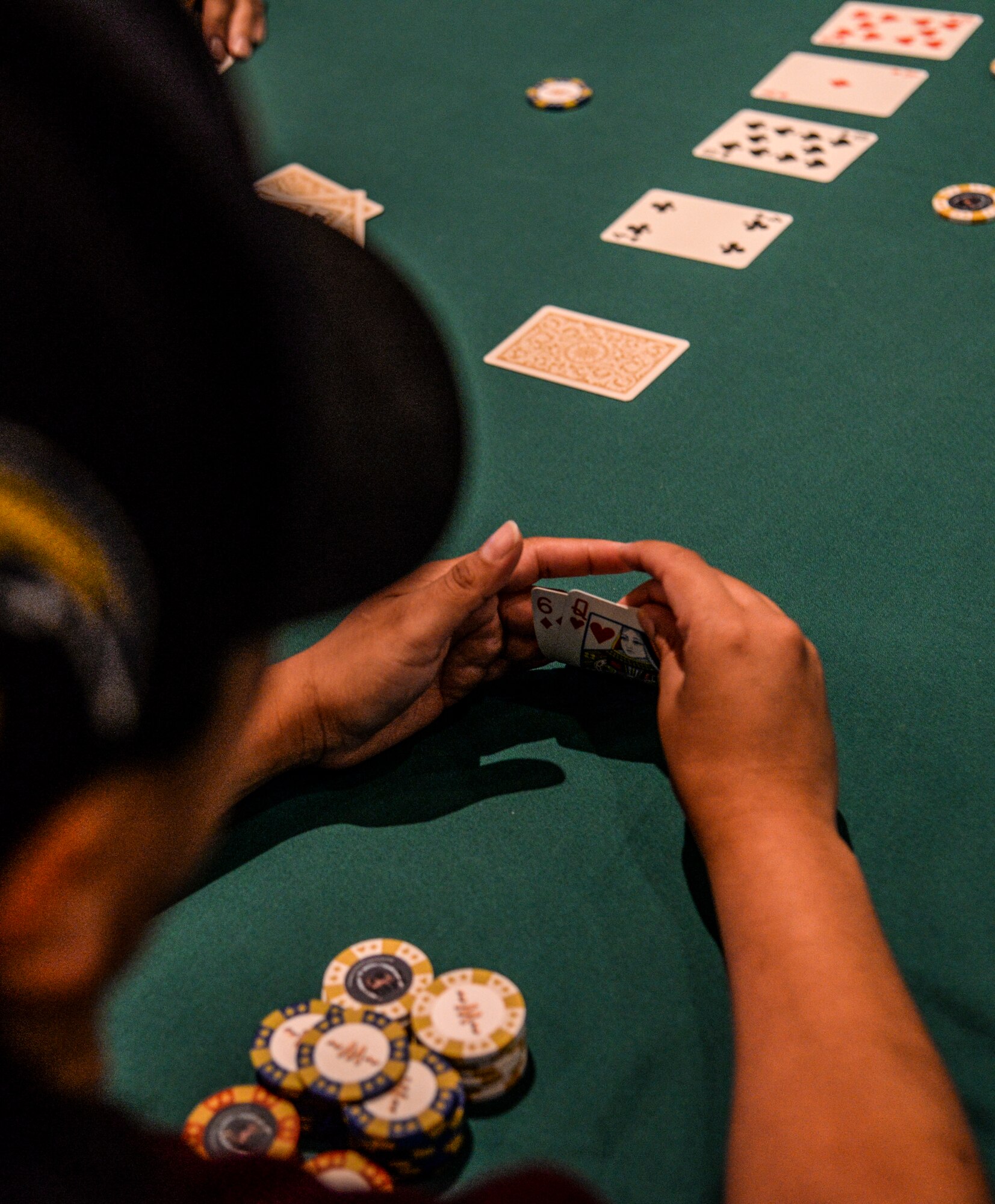 Staff Sgt. Irma “Mo” Meza-Orozco, 51st Dental Squadron dental technician, peeks at her cards during a Texas Hold ’em tournament in the Osan Cup at Osan Air Base, Republic of Korea, Sept. 29, 2015. The Osan cup is a sport-oriented, two-day event that puts squadrons and service members against each other in a battle royal to show who has the most skill, strength and knowledge. (U.S. Air Force photo/Tech. Sgt. Travis Edwards)