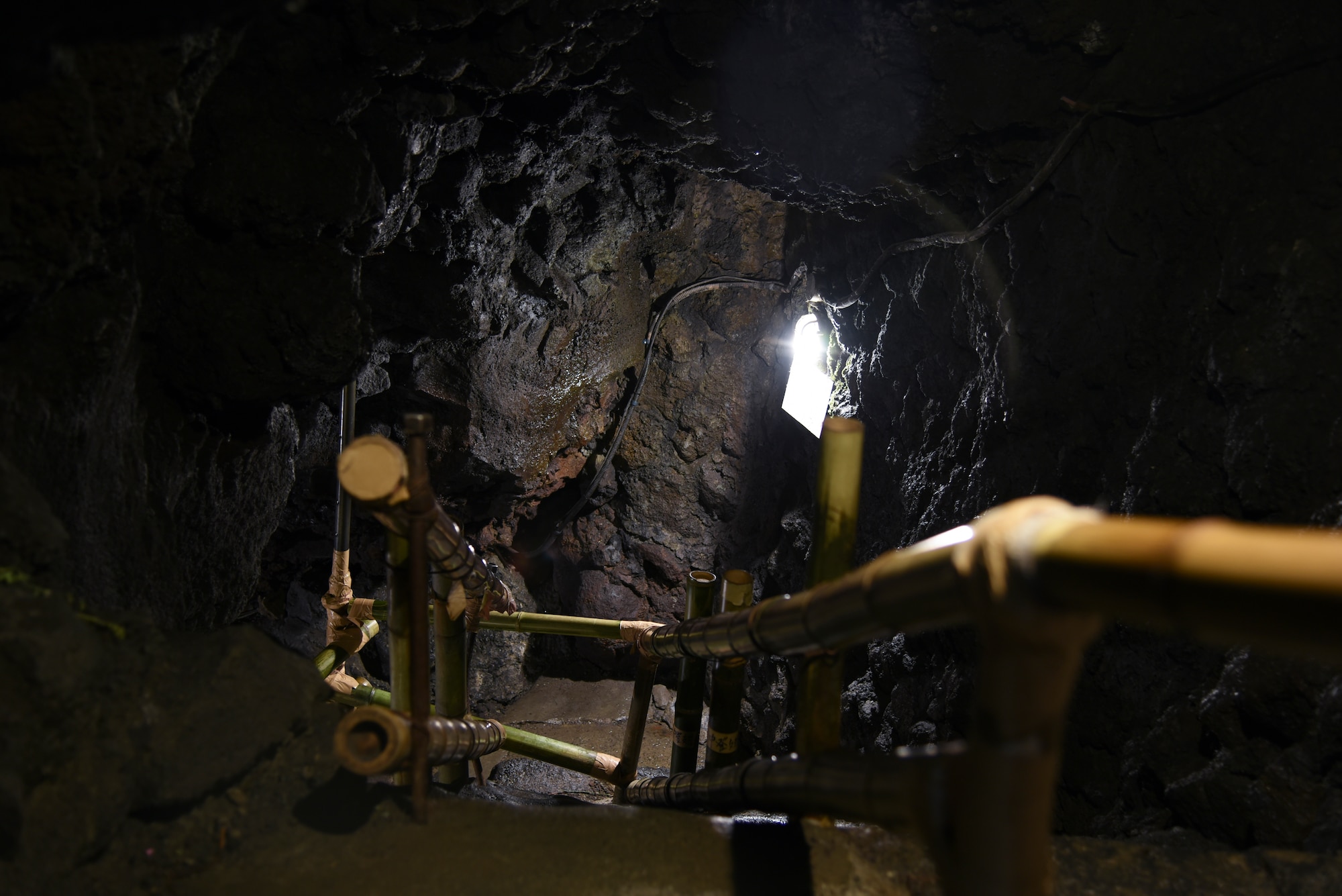 A Bamboo handrail and narrow steps signify the entrance at the Narusawa Hyouketsu Ice Cave in Yamanashi, Japan, Sept. 5, 2015. The Narusawa Hyouketsu Ice Cave stays an average temperature of 37 degrees Fahrenheit year-round. (U.S. Air Force photo by Senior Airman Michael Washburn/Released)
