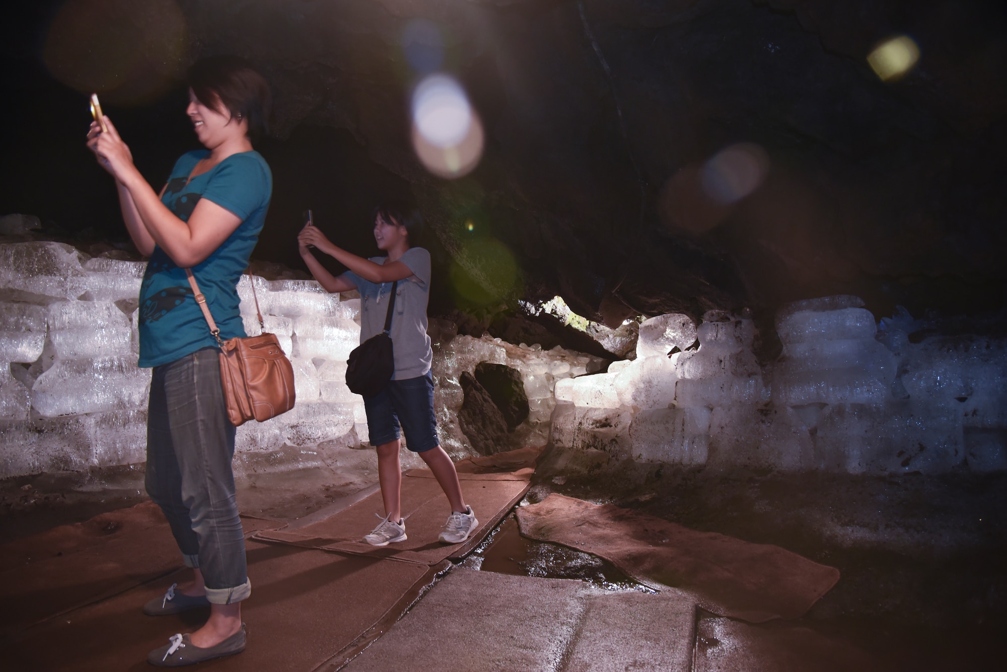 Japanese sightseers stop and take pictures in the large main portion of the Narusawa Hyouketsu Ice Cave in Yamanashi, Japan, Sept. 5, 2015. During the month of April, water droplets from the ceiling form huge icicles that reach sizes of nearly 10-feet high. (U.S. Air Force photo by Senior Airman Michael Washburn/Released)