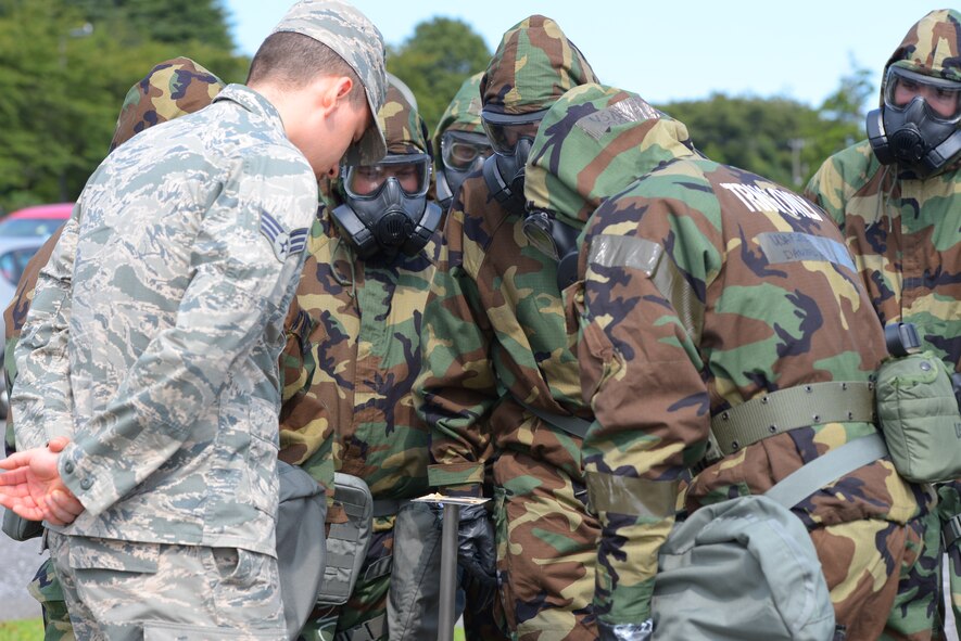 Senior Airman Zachary Lutes, 374th Civil Engineer Squadron emergency management journeyman, instructs Airmen concerning chemical detection paper during a Chemical, Biological, Radiological, Nuclear and Explosives defense survival skills refresher course at Yokota Air Base, Japan, Sept. 29, 2015. The CBRNE defense survival skills course takes personnel through the procedures of donning chemical resistant gear, identifying and securing unexploded ordnance and using chemical detection paper to locate and identify chemical attacks. (U.S. Air Force Photo by Airman 1st Class Elizabeth Baker/Released)