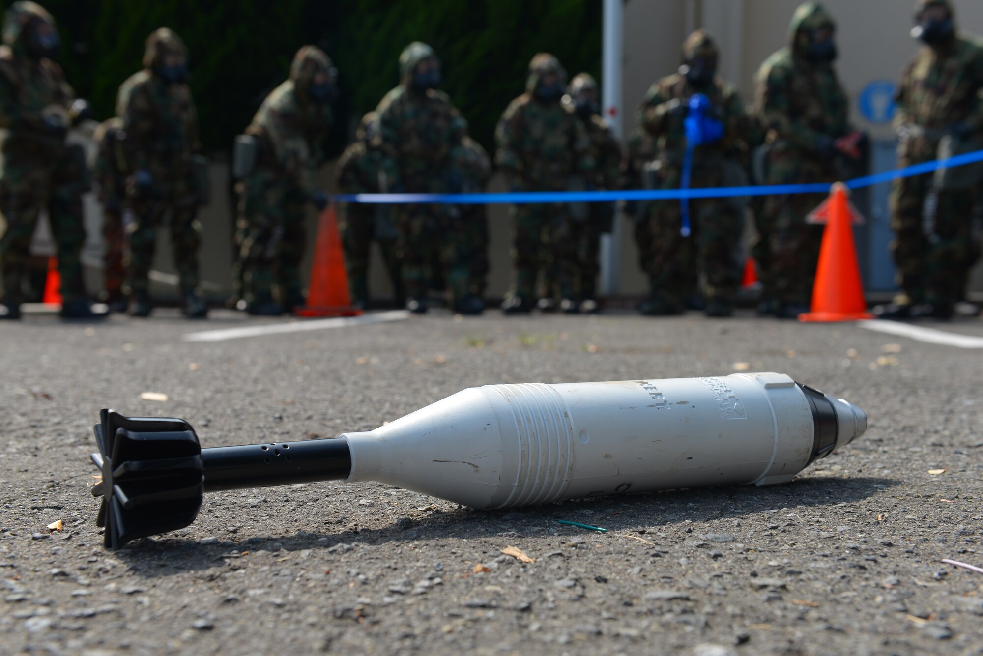 Participants in a Chemical, Biological, Radiological, Nuclear and Explosives defense survival skills refresher course practice cordoning a simulated unexploded ordnance at Yokota Air Base, Japan, Sept. 29, 2015. Realistic scenarios like those in the CBRNE course educate Airmen and give them personal experiences with possible explosives, allowing more effective responses in the case of real-world emergencies. (U.S. Air Force Photo by Airman 1st Class Elizabeth Baker/Released)