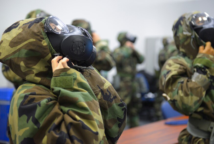 Participants in a Chemical, Biological, Radiological, Nuclear and Explosives defense survival skills refresher course don chemical gear at Yokota Air Base, Japan, Sept. 29, 2015. Airmen must take the defense survival skills course every year to ensure that team Yokota is ready for every contingency. (U.S. Air Force Photo by Airman 1st Class Elizabeth Baker/Released)