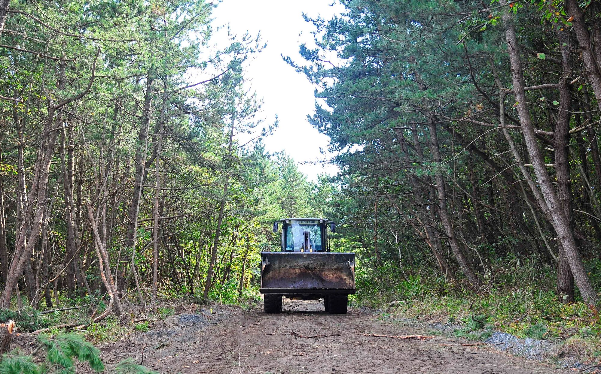 A front-end loader drives down a road at Draughon Range, Japan, Sept. 29, 2015. The 35th Civil Engineer Squadron pavement and construction equipment flight cleared an area of Draughon Range and widened the road leading to the area for the construction of a new Combat Arms Training and Maintenance facility. (U.S. Air Force Tech. Sgt. April Quintanilla/Released)