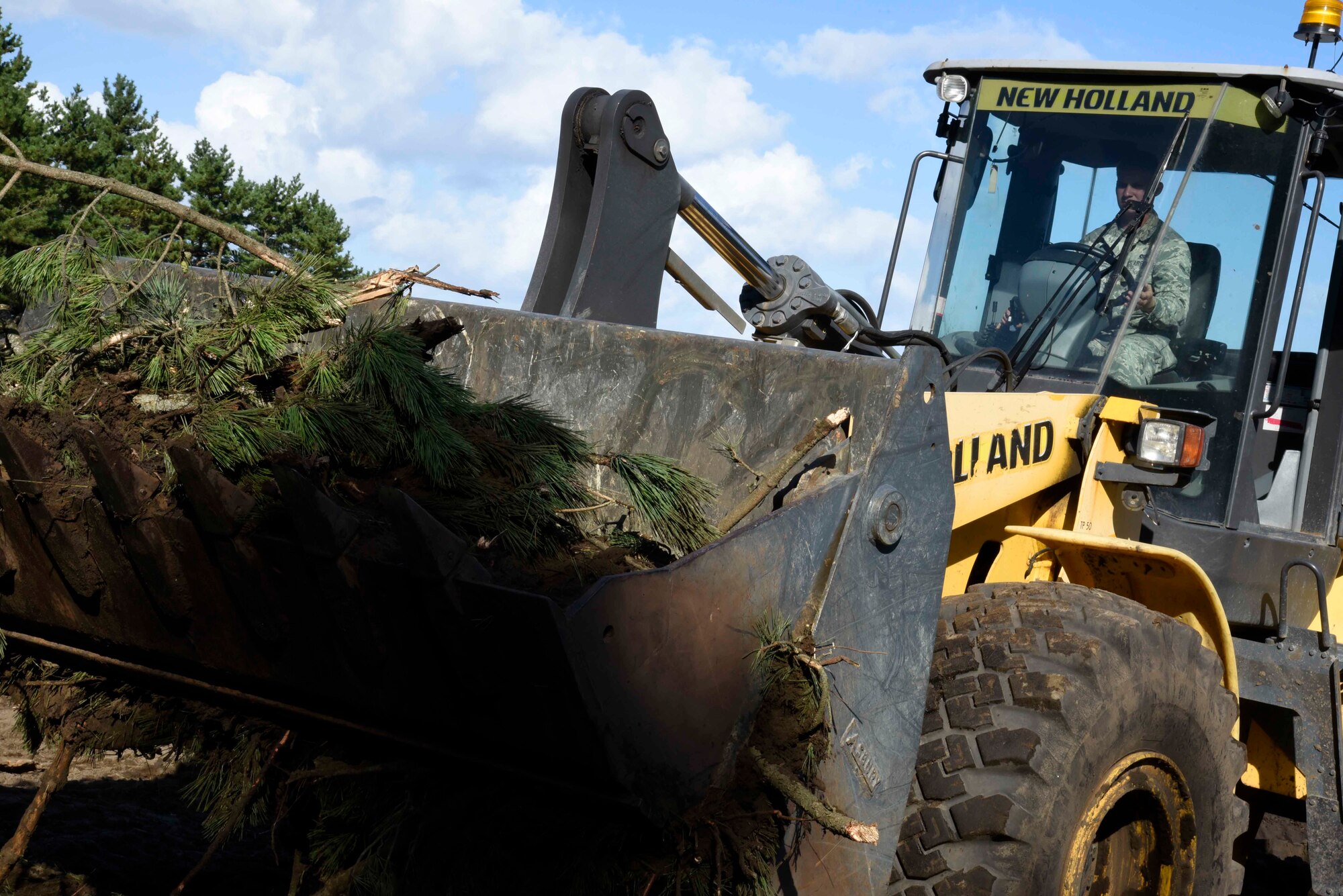 U.S. Air Force Airman Jeffrey Waldron, 35th Civil Engineer Squadron pavement and construction equipment apprentice, removes tree branches with a front-end-loader at Draughon Range, Japan, Sept. 29, 2015. Construction on the new Combat Arms Training and Maintenance facility began Aug. 20 and is slated to be complete near the end of 2016. (U.S. Air Force Airman 1st Class Jordyn Fetter/Released)