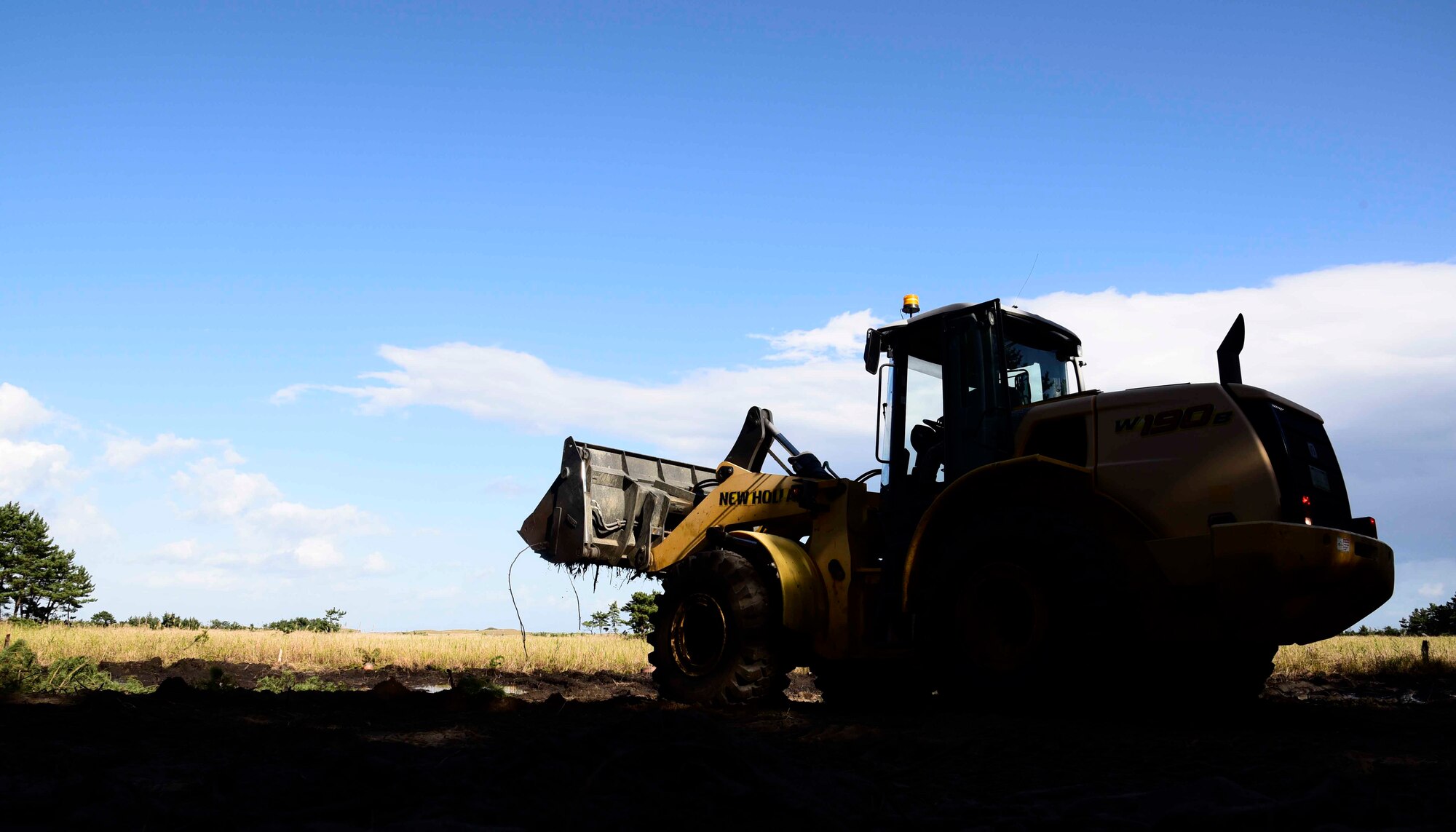 U.S. Air Force Airman Jeffrey Waldron, 35th Civil Engineer Squadron pavement and construction equipment apprentice, drives a front-end loader at Draughon Range, Japan, Sept. 29, 2015. The 35 CES pavement and construction equipment flight, better known as the ?dirt boys,? completed the first step in the building of the new Combat Arms Training and Maintenance facility. (U.S. Air Force Airman 1st Class Jordyn Fetter/Released)