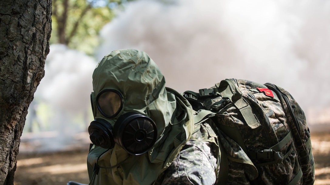 Republic of Korea Marine Lance Cpl. Jun Shin puts on his gas mask during a gas attack scenario as part of Korea Marine Exchange Program 15-12 at Gunha-Rhi, Republic of Korea, Sept. 17, 2015. The U.S. and ROK Marines practiced quickly putting on their gas mask and carrying the wounded to safety. KMEP 15-12 is an exercise in a series of continuous bilateral training exercises that enhance the ROK and U.S. alliance, promote stability on the Korean Peninsula and strengthen ROK and U.S. military capabilities and interoperability. Shin, from Ulsan, ROK, is with 2nd Company, 11th Battalion, 1st Regiment, 2nd Marine Division, ROK Headquarters Marine Corps.