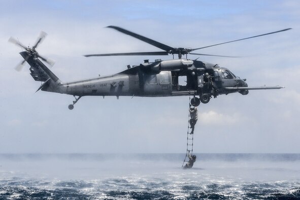 An HH-60G Pave Hawk from the 33rd Rescue Squadron at Kadena Air Base, Japan, performs a rope-ladder recovery with Airmen from the 320th Special Tactics Squadron during an amphibious operations exercise Sept. 22, 2015, off the west coast of Okinawa, Japan. Special tactics team Airmen are organized, trained, and equipped to conduct special operations core tasks during high-risk combat operations. (U.S. Air Force photo/Senior Airman John Linzmeier)