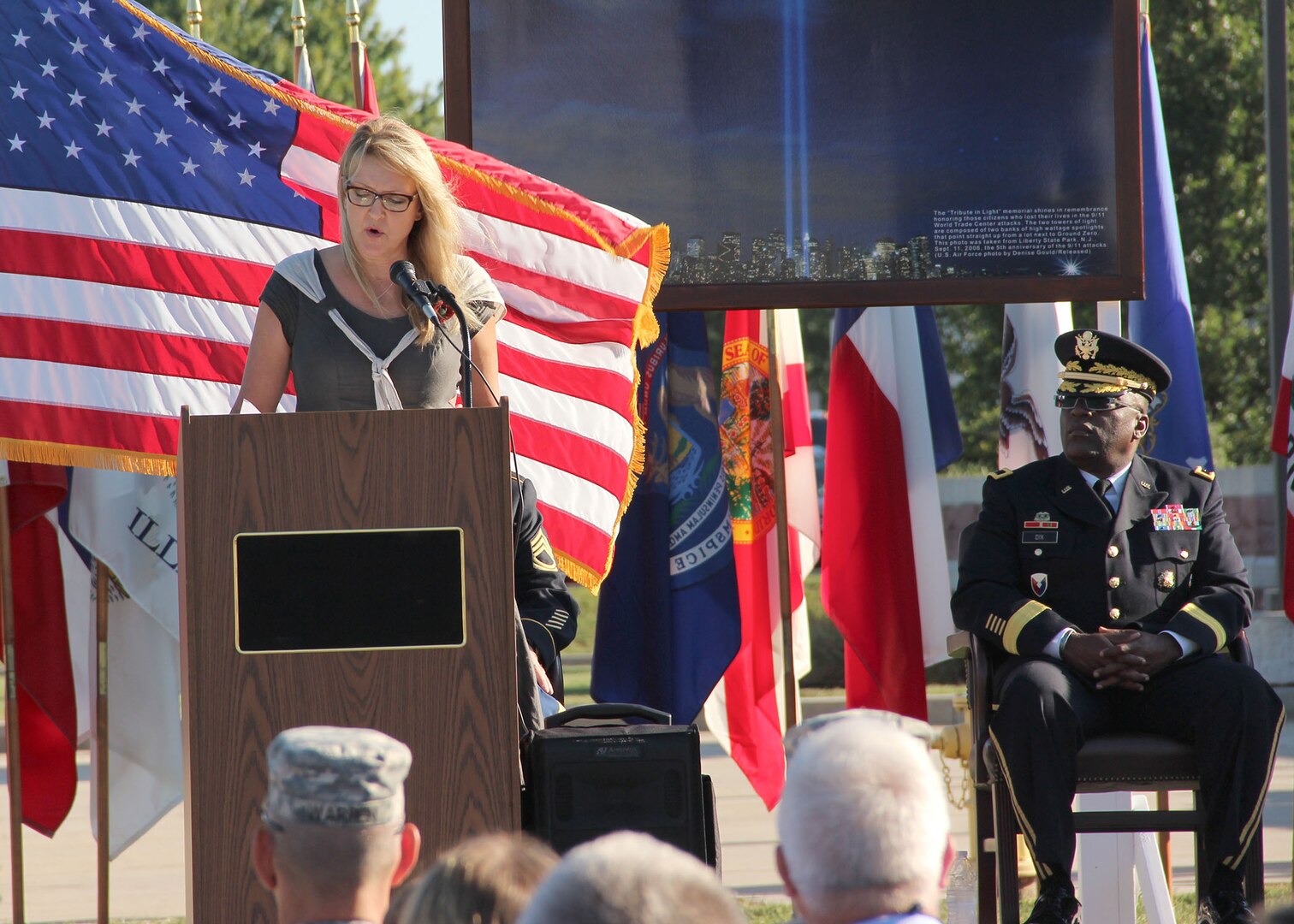 Brig. Gen. Richard B. Dix listens as Carmen Gordon, the Gold Star wife of Army Master Sgt. Gary Gordon, speaks of her husband’s heroics and ultimate sacrifice during a Patriot Day and POW/MIA Remembrance Ceremony. (Photo by Sherre Mitten-Bell, DLA Distribution Susquehanna, Pa.)