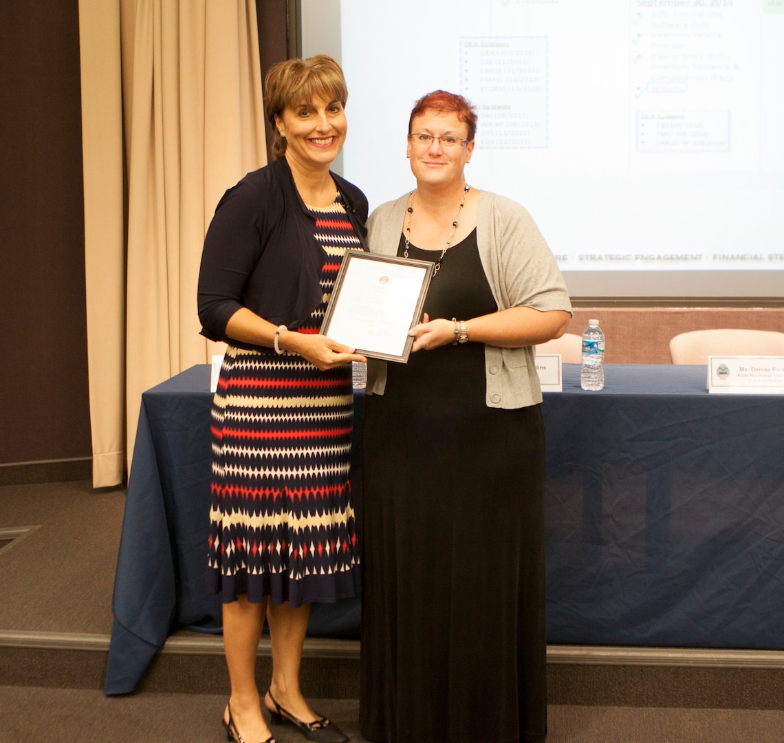 Simone Reba, deputy director of Defense Logistics Agency Finance presents Denise Parker, Audit Readiness Distribution site lead with a letter of appreciation for the efforts put forth by the entire Distribution Audit Readiness team.