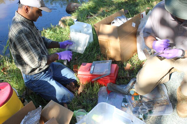 Dr. Upal Ghosh, Professor of Chemical, Biochemical, and Environmental Engineering at UMBC (left) and Brian Ventura, Installation Restoration Program Manager at MCB Quantico (right), assemble sheets of polyethylene. These sheets will be used to absorb and measure levels of PCBs in Abraham’s Creek. Some sheets will be buried at the bottom of the creek and some floated in the water to measure the levels of PCBs in both places. 