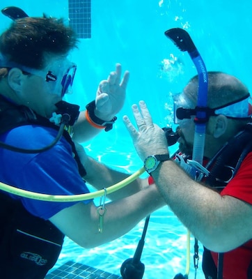Students Michael Winkler and Tommy Kirklin signal to each other that they are OK as they practice buddy breathing – an emergency out-of-air procedure when scuba diving.