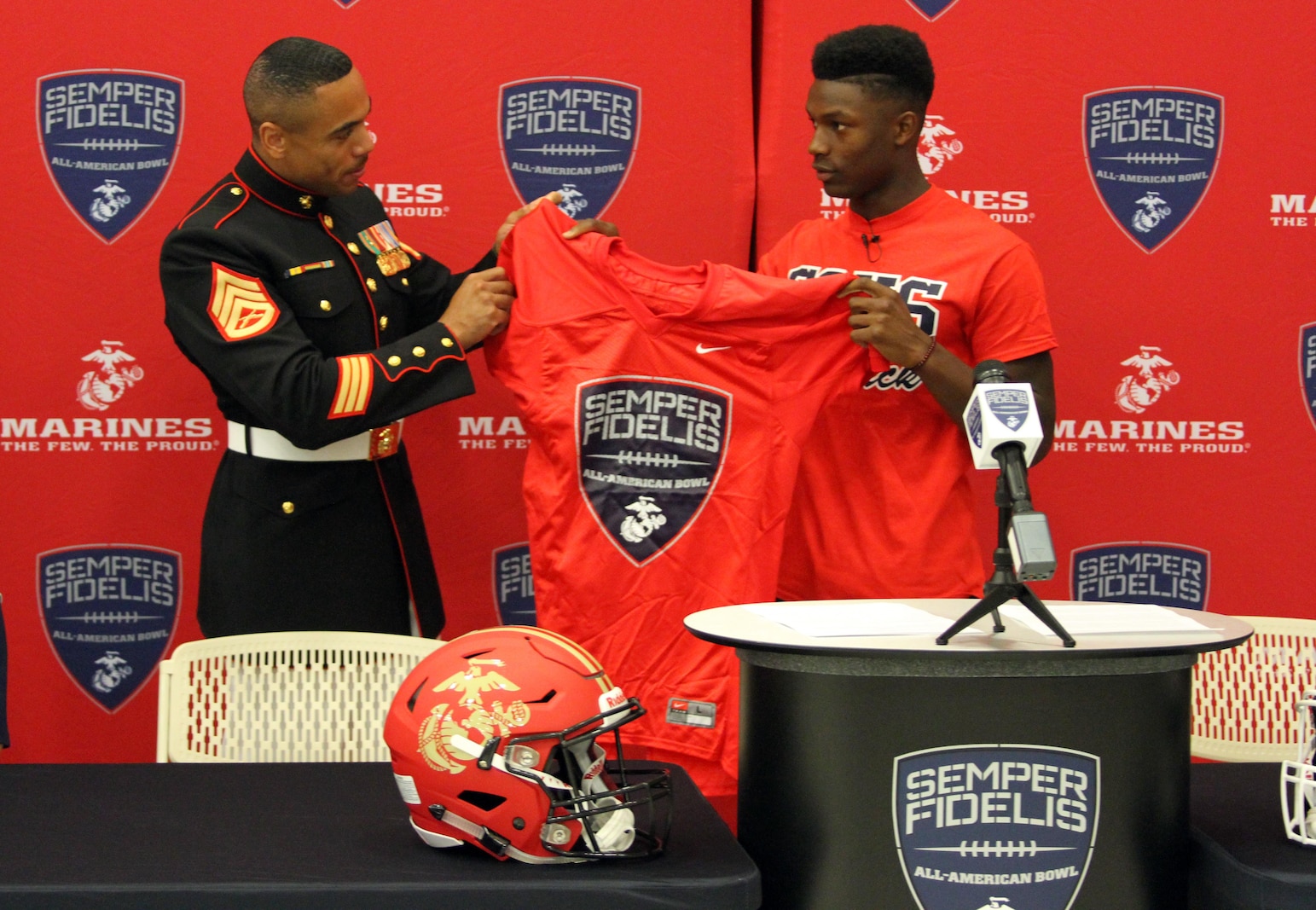 Staff Sgt. Curtis Rankin, a recruiter with Marine Corps Recruiting Substation Temecula, presents Demetric Felton with a jersey for the 2016 Semper Fidelis All-American Bowl at Great Oak High School in Temecula, Calif., Oct. 1. Felton is selected to play both a running back and a strong-side linebacker position for the West Coast team.