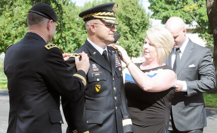 Lt. Gen. Perry L. Wiggins (left), U.S. Army North (Fifth Army) commanding general and senior Army commander of Fort Sam Houston and Camp Bullis, along with Wanda Harris, pin major general rank onto Brian C. Harris during his promotion ceremony at the Quadrangle Sept. 18. 