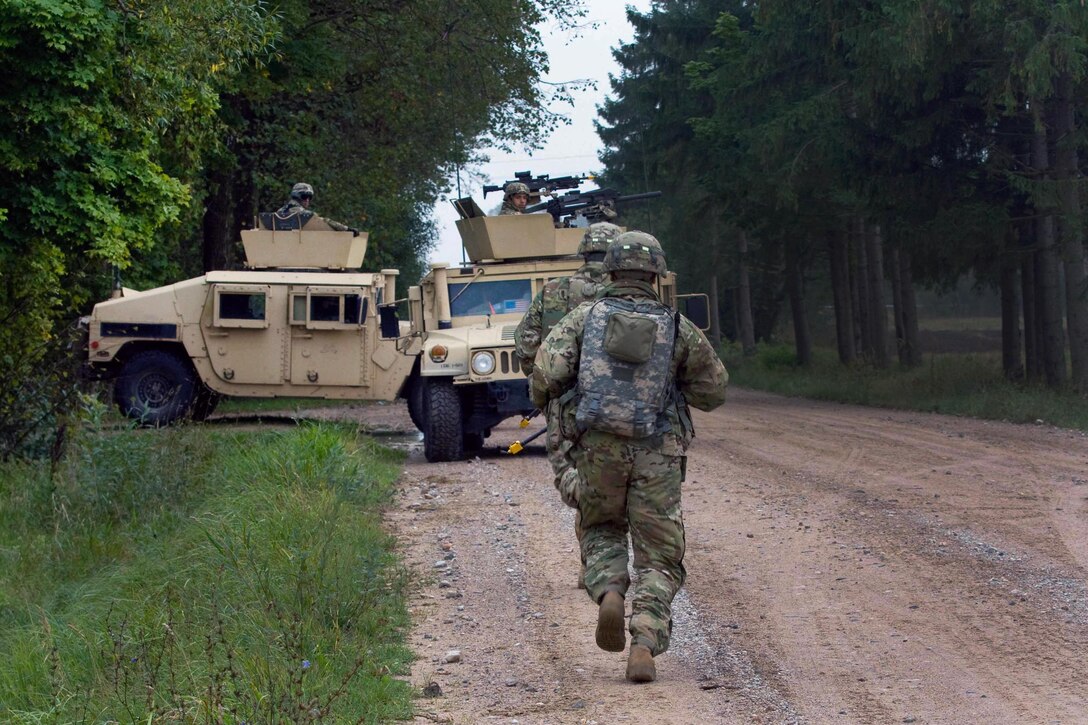 U.S. soldiers run back to their vehicles after assisting in medically evacuating a mocked injured soldier during Exercise King Strike in Panevezys, Lithuania, Sept. 22, 2015. The soldiers are assigned to Company D, 1st Battalion, 503rd Infantry Regiment, 173rd Airborne Brigade. The soldiers are in Europe as part of Atlantic Resolve, a demonstration of continued U.S. commitment to the collective security of NATO and to enduring peace and stability in the region. U.S. Army Photo by Sgt. James Avery