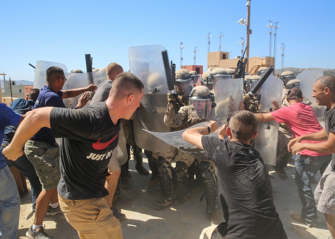 Protesters in a simulated mob attempt to take a shield away from a Marine in a riot-control squad during a riot-control tactics course aboard Marine Corps Base Camp Pendleton, Calif., Sept. 25, 2015. The course was part of an annual training event meant to educate Marines in the de-escalation of situations, while showing appropriate escalation of force in response to riots. (U.S. Marine Corps photo by Pfc. Devan K. Gowans/Released)
