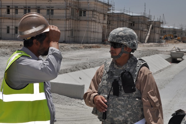 Adrian Hernandez, a U.S. Army Corps of Engineers civilian project engineer from the Fort Worth District, discusses ongoing work at the new Ministry of the Interior headquarters in Kabul, Afghanistan, June 2015, with a Local National Quality Assurance representative. MoI oversees the Afghan National Police force.