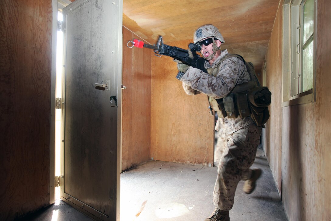 Lance Cpl. Patrick Marlowe clears a room during a security forces training exercise at Marine Corps Base Camp Lejeune, N.C., Sept. 30, 2015. More than 30 Marines with 2nd Low Altitude Air Defense Battalion participated in the week-long training, covering a full spectrum of scenarios they may encounter while deployed. Marlowe is a low altitude air defense gunner with the battalion. (U.S. Marine Corps photo by Lance Cpl. Jason Jimenez/Released)