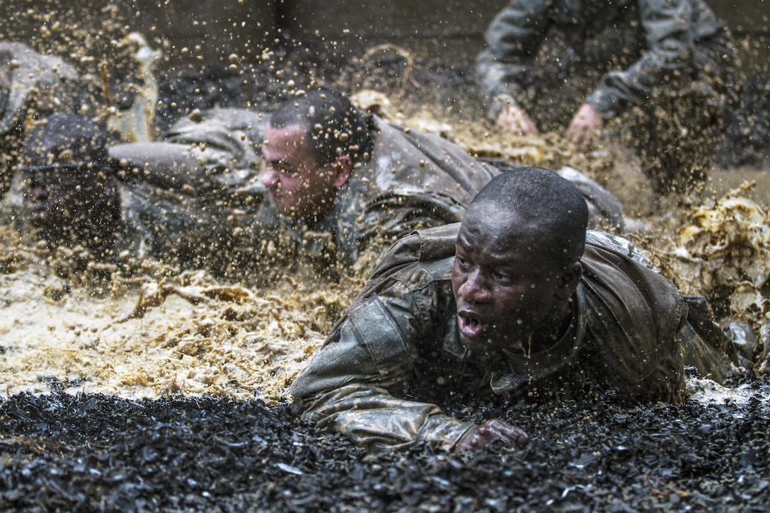 Soldiers in their second week of basic combat training low-crawl through a mud pit serving as the final obstacle of the Fit to Win endurance course on Fort Jackson, S.C., Oct. 1, 2015. The soldiers are with Company B, 3rd Battalion, 34th Infantry Regiment. U.S. Army photo by Sgt. 1st Class Brian Hamilton