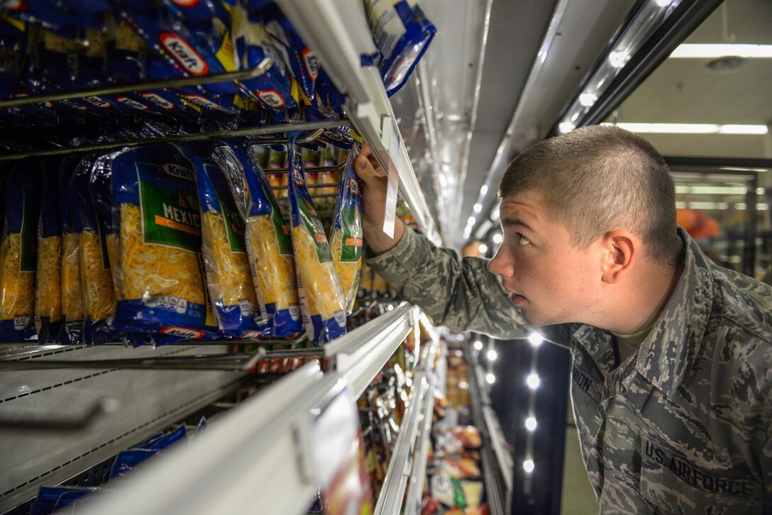 An Airman-in-Training restocks the shredded cheese section at the Defense Commissary Agency cooler shelves on Sheppard Air Force Base, Texas, Sept. 27, 2015.  More than 150 Airmen and volunteers helped rescue more than $200,000 in perishable grocery items from a lighting strike that shut down the commissary power. (U.S. Air Force photo/Tech. Sgt. Mike Meares)
