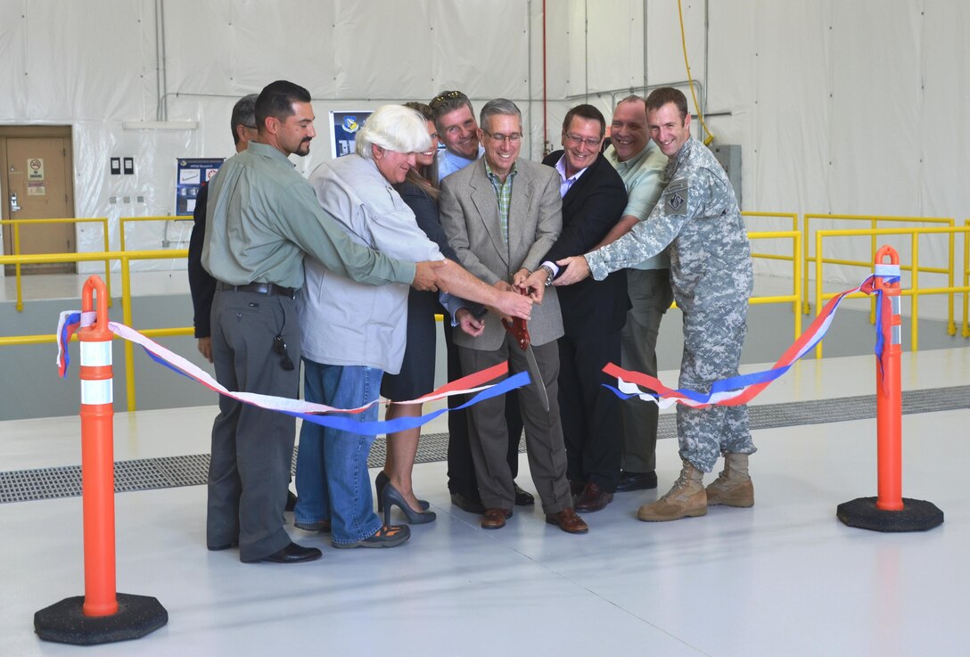 KIRTLAND AIR FORCE BASE, N.M. – Deputy District Commander Maj. Jason Melchior (far right) and District Project Manager Filemon Gallegos (far left) help cut the ribbon officially opening the Building 903 Lab Space, Sept. 23, 2015. 