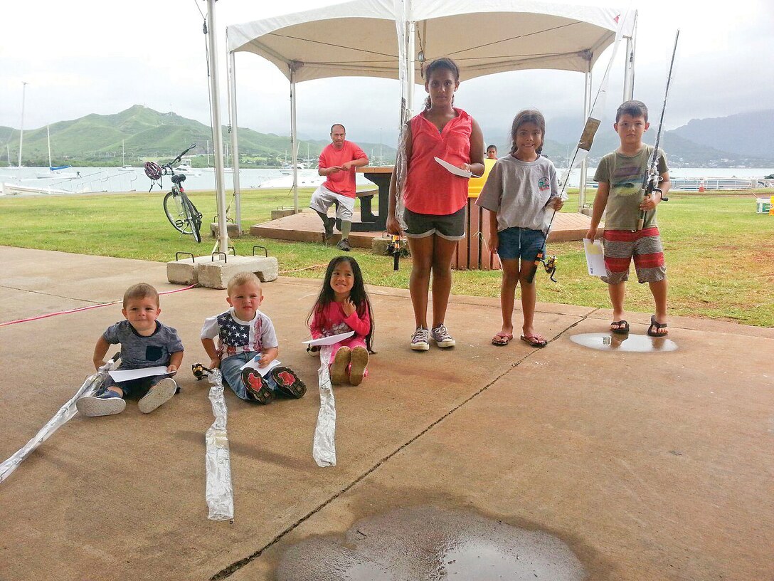 MARINE CORPS BASE HAWAII — Participants in the children’s category of the Night Shoreline Fishing Tournament pose for a photo in between catch-and-release fishing at the base marina, Sept. 26, 2015. The Night Shoreline Fishing Tournament featured prizes in two categories: Adults and children, who were 12 years old and younger. Each child received a free fishing rod for participating. Appearing in order from left to right: Carter Gomez; Conner Gomez; Aria Guieb; Alex Lacalamito; Kaitlyn Morales and Ethan Rau. The tournament was the first of its kind hosted by marina staff and part of Marine Corps Community Services’ ongoing mission to assist service members and civilians. The marina staff provides facilities, programs and services in direct support of the MCB Hawaii community for recreation using the installation’s available resources. (Photo courtesy of Marine Corps Base Hawaii’s Outdoor Recreation Center and Marina)