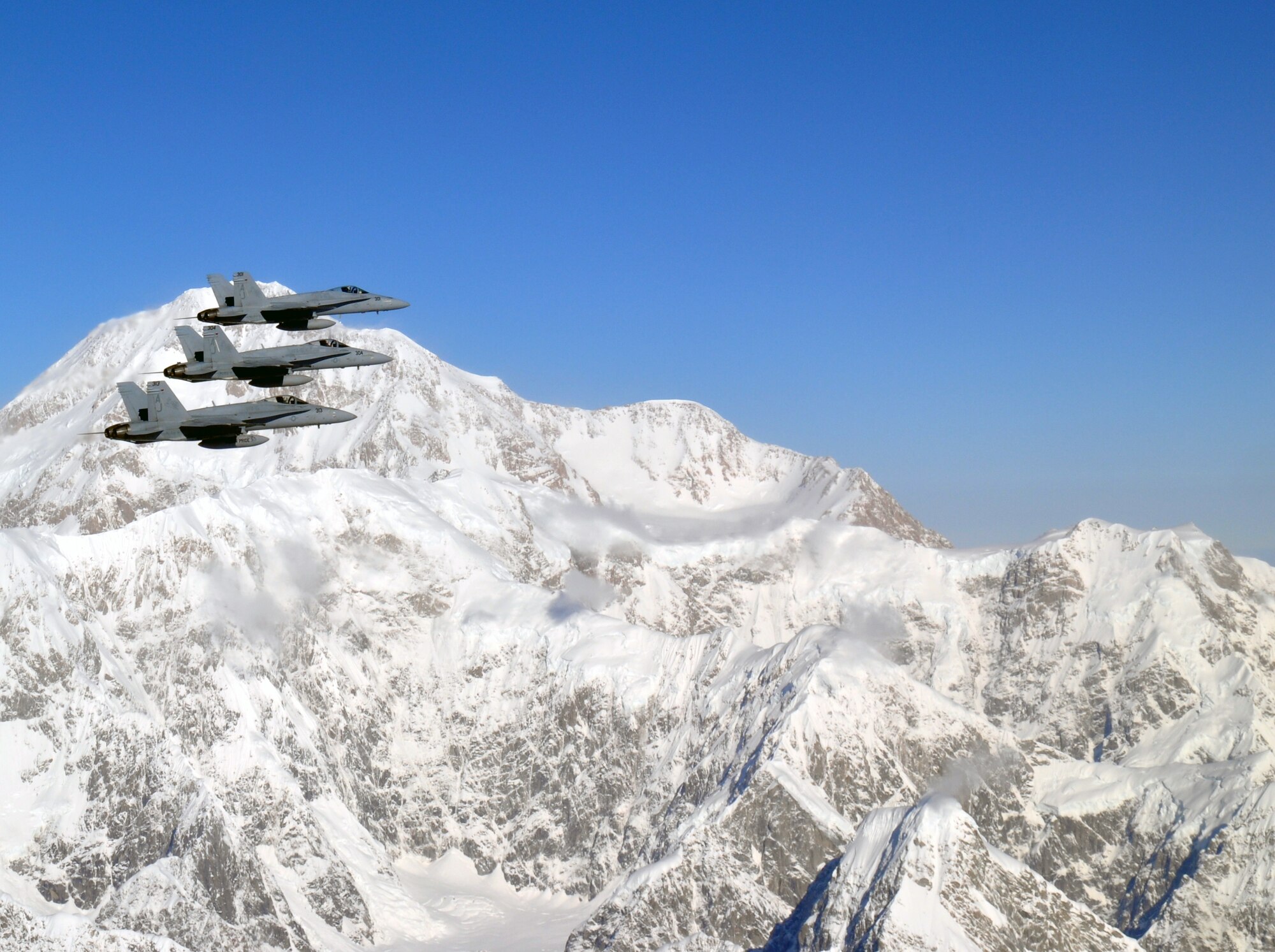 Three Navy F-18 Hornets fly over Alaska's mountains during dissimilar air combat training, which took place Sept. 14 through Sept. 25, 2015. The Hornets flew with 90th Fighter Squadron F-22 Raptors as part of DACT, a training operation in which fundamentally different airframes work against and with each other. (Courtesy photo)