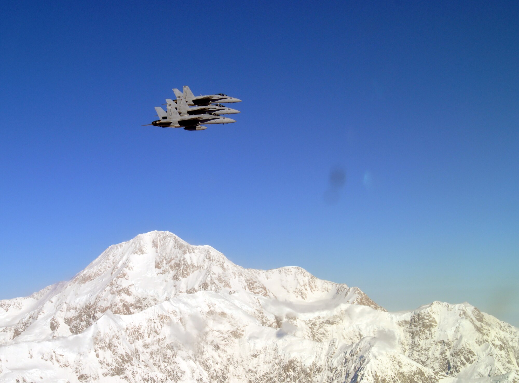 Three Navy F-18 Hornets fly over Alaska's mountains during dissimilar air combat training, which took place Sept. 14 through Sept. 25, 2015. The Hornets flew with 90th Fighter Squadron F-22 Raptors as part of DACT, a training operation in which fundamentally different airframes work against and with each other. (Courtesy photo)