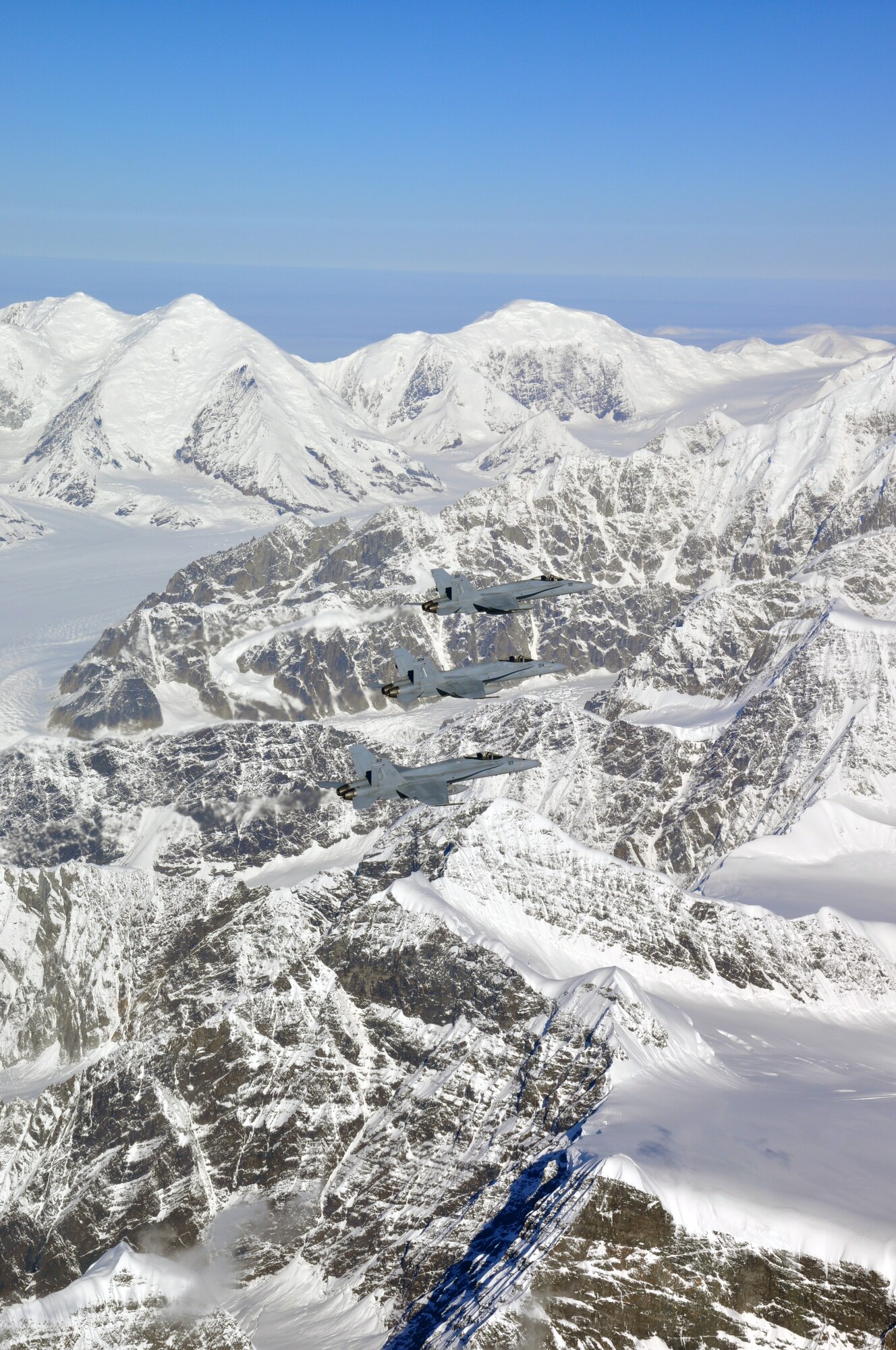Three Navy F-18 Hornets fly over Alaska's mountains during dissimilar air combat training, which took place Sept. 14 through Sept. 25, 2015. The Hornets flew with 90th Fighter Squadron F-22 Raptors as part of DACT, a training operation in which fundamentally different airframes work against and with each other. (Courtesy photo)