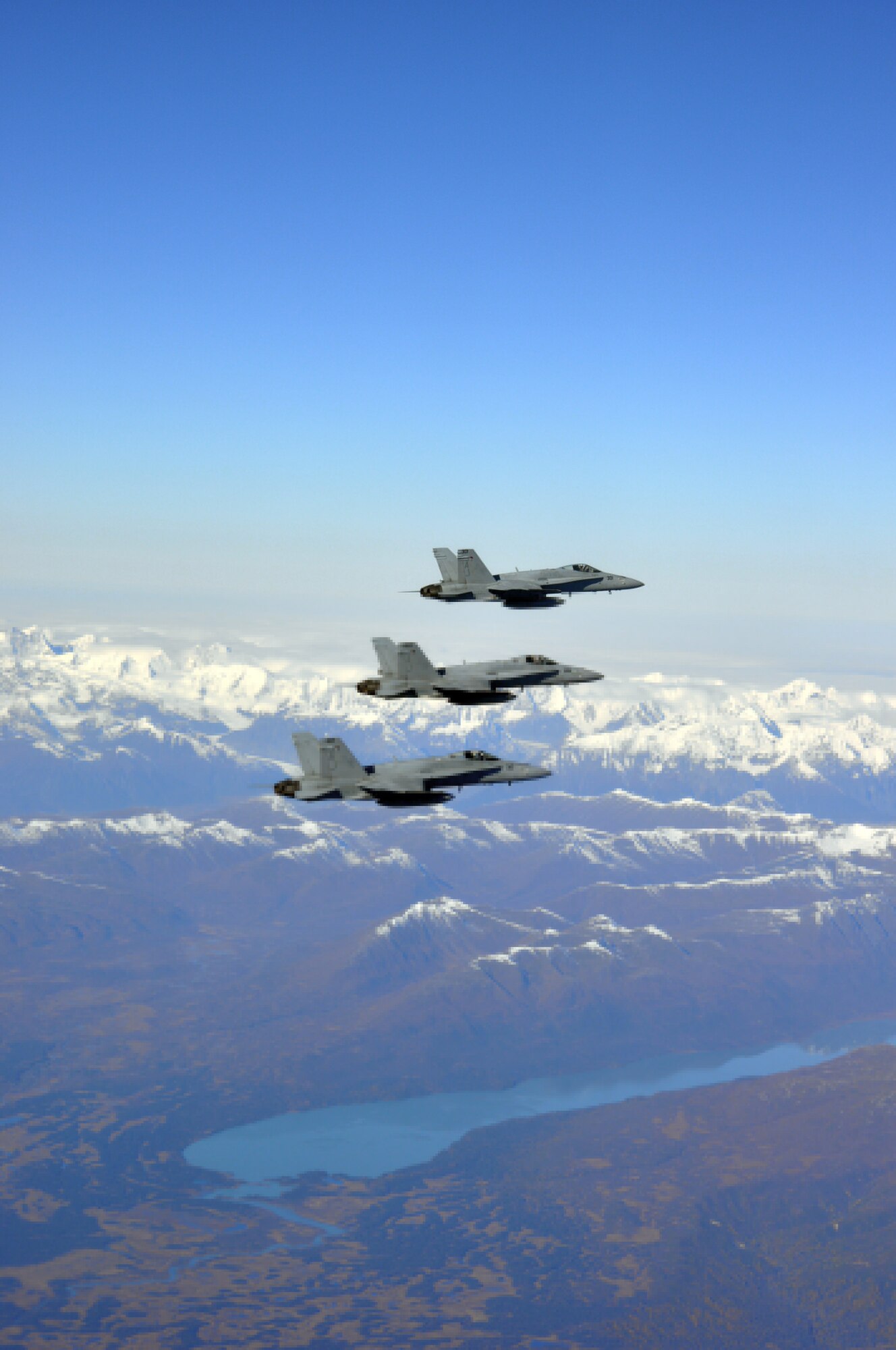 Three Navy F-18 Hornets fly over Alaska's mountains during dissimilar air combat training, which took place Sept. 14 through Sept. 25, 2015. The Hornets flew with 90th Fighter Squadron F-22 Raptors as part of DACT, a training operation in which fundamentally different airframes work against and with each other. (Courtesy photo)