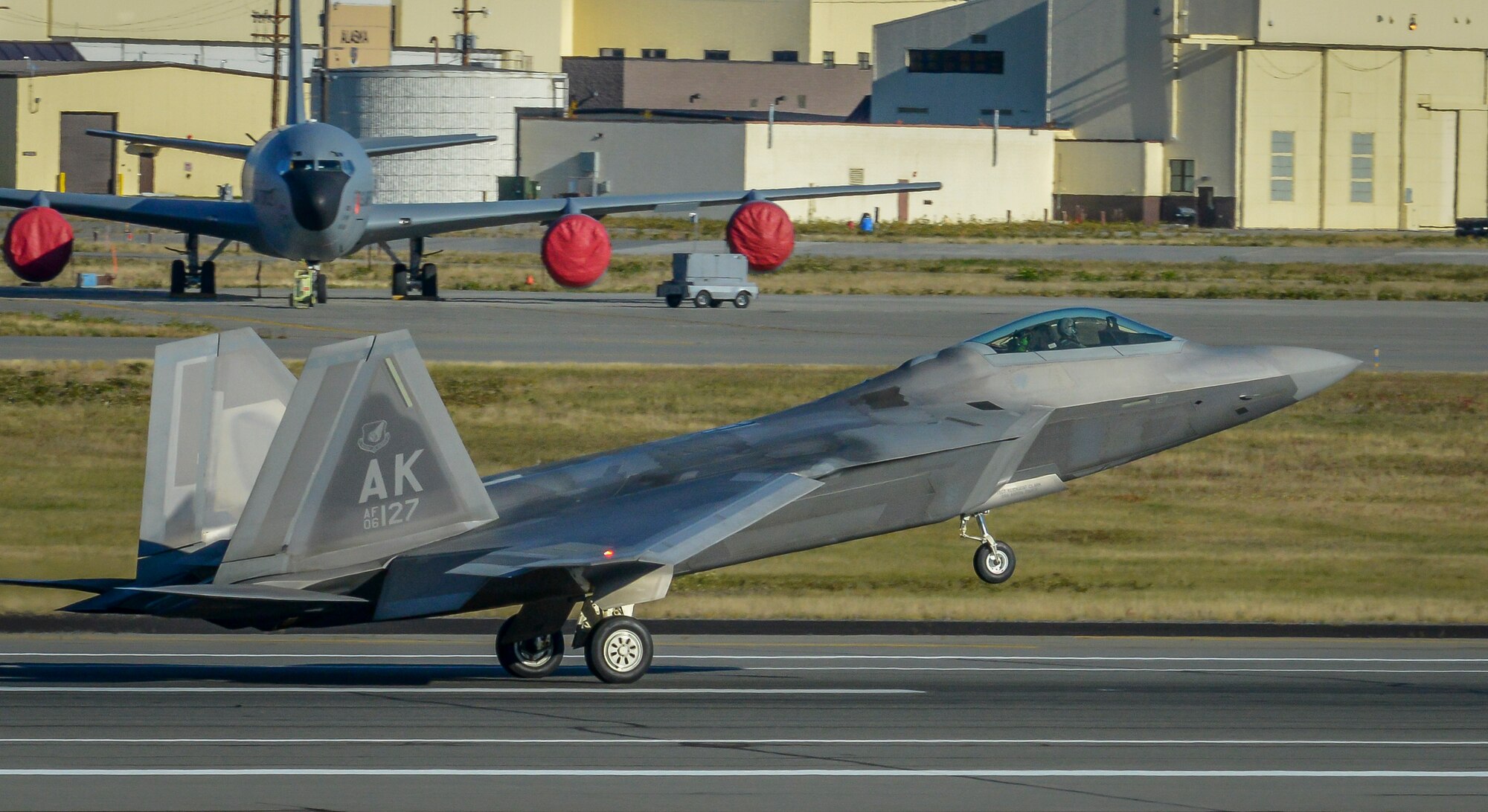An F-22 Raptor assigned to the 525th Fighter Squadron, Joint Base Elmendorf-Richardson, Alaska leaves the flightline shortly before Navy F-18 Hornets line up for dissimilar air combat training Sept. 23, 2015. DACT is involves different types of airframes training with and against each other. The goal is to expand pilots’ proficiency in as many circumstances as possible. (U.S. Air Force photo/Airman 1st Class Kyle Johnson)