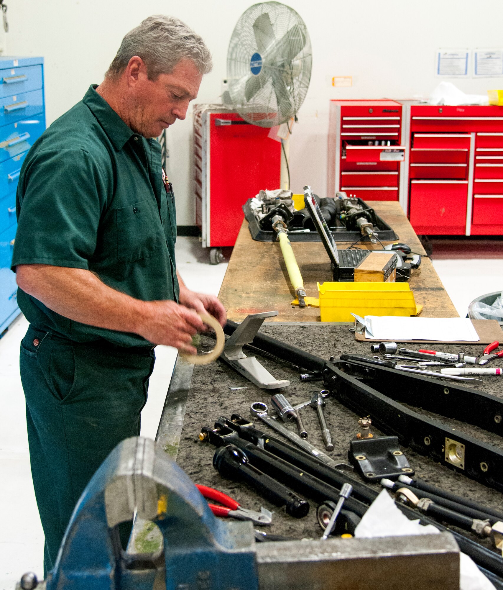 Retired Master Sgt. Tim Brightman, M1 Support Services aircraft mechanic for the 37th Helicopter Squadron , begins to place tape on a UH-1N “Huey” Bell Helicopter stabilizer bar mixing lever Oct. 2, 2015, in the 37th HS hangar on F.E. Warren Air Force Base, Wyo. The part will be painted black and replace a worn lever on one of the squadron’s Hueys. (U.S. Air Force photo by Senior Airman Jason Wiese)