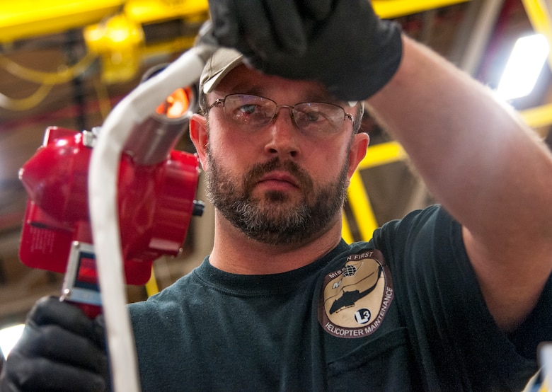 Travis Penfold, M1 Support Services aircraft mechanic for the 37th Helicopter Squadron , shrink wraps a protective casing on a starter generator’s wires Oct. 2, 2015, in the 37th HS hangar on F.E. Warren Air Force Base, Wyo. The work is part of “phase maintenance,” which is scheduled upkeep for UH-1N “Huey” Bell Helicopters performed after a certain number of flight hours. (U.S. Air Force photo by Senior Airman Jason Wiese)