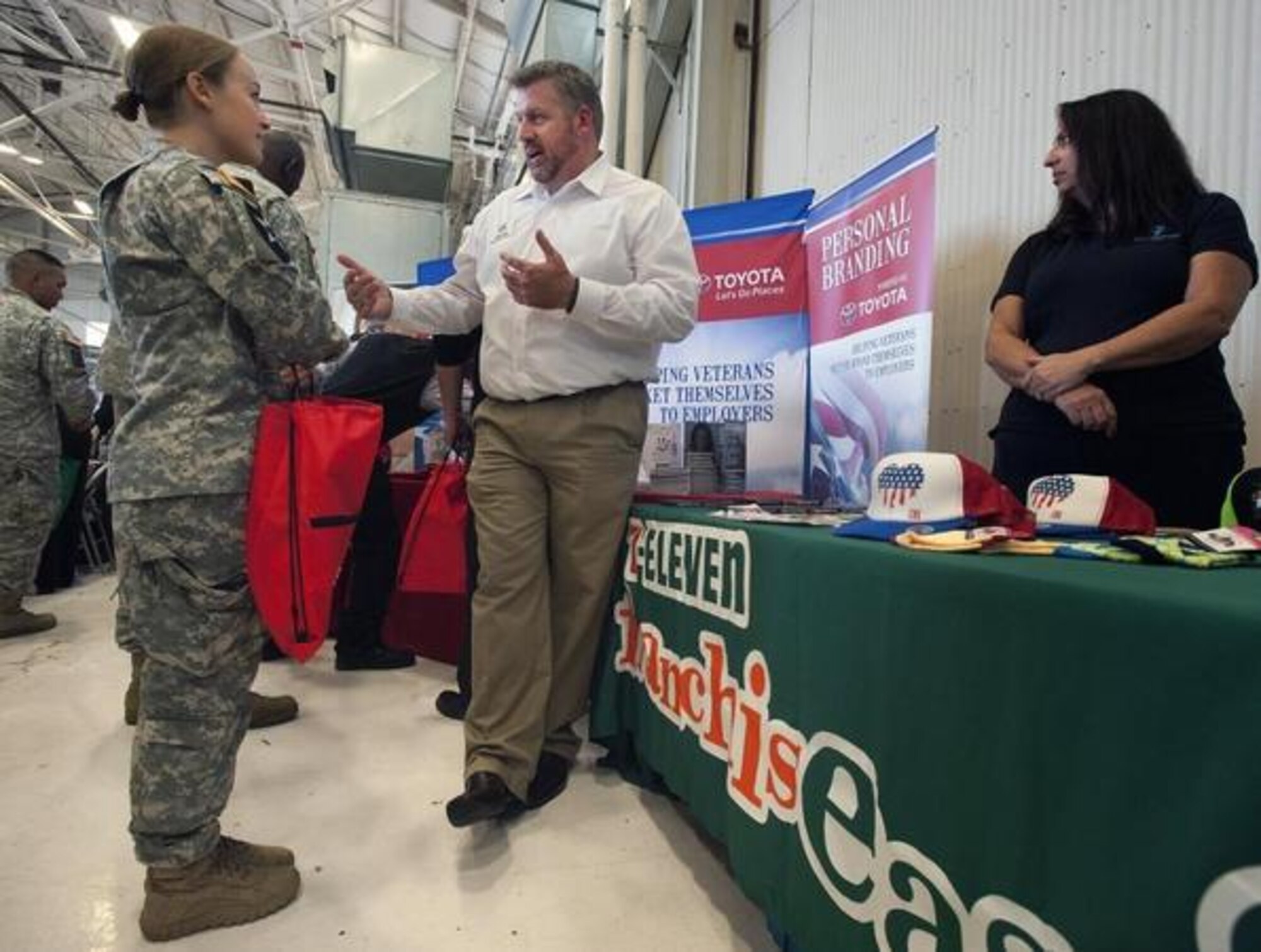 Capt. Laura Hoover, left, of the Warrior Transition Battalion, visits with recruiter Justin Hunt about marketing and managerial opportunities with with 7-Eleven Sept. 24 during the Washington State Service Member for Life Summit job fair in Hangar 10 on McChord Field. More than 3,000 service members and civilians attended the annual event. (Northwest Guardian photo/Scott Hansen)