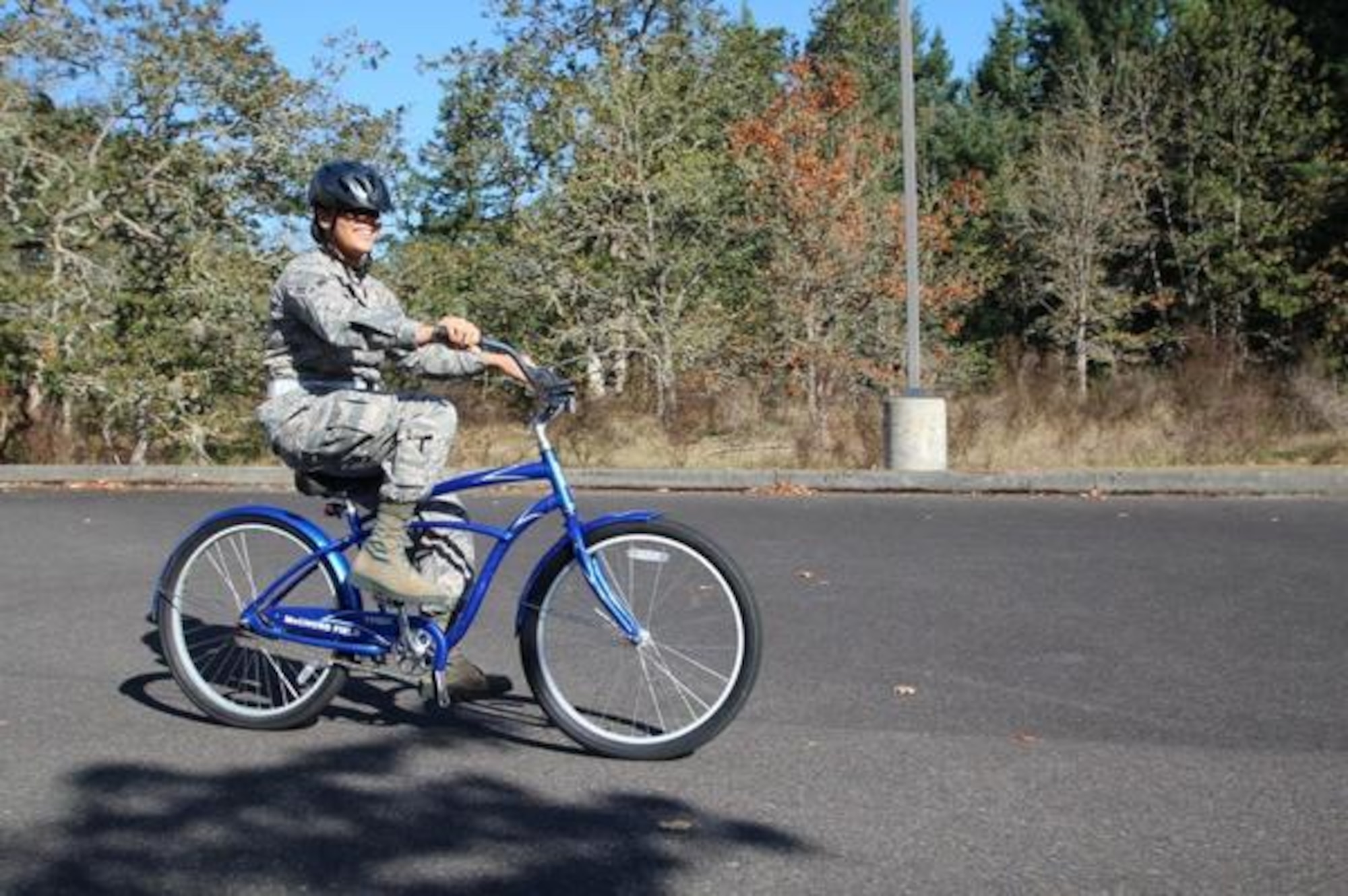 Airmen 1st Class Arianna Cooper rides on a McChord Blue Bike. Cooper uses it to get around McChord Field easily since she doesn’t have a car. (Northwest Guardian photo/Christina Carmen Crea)