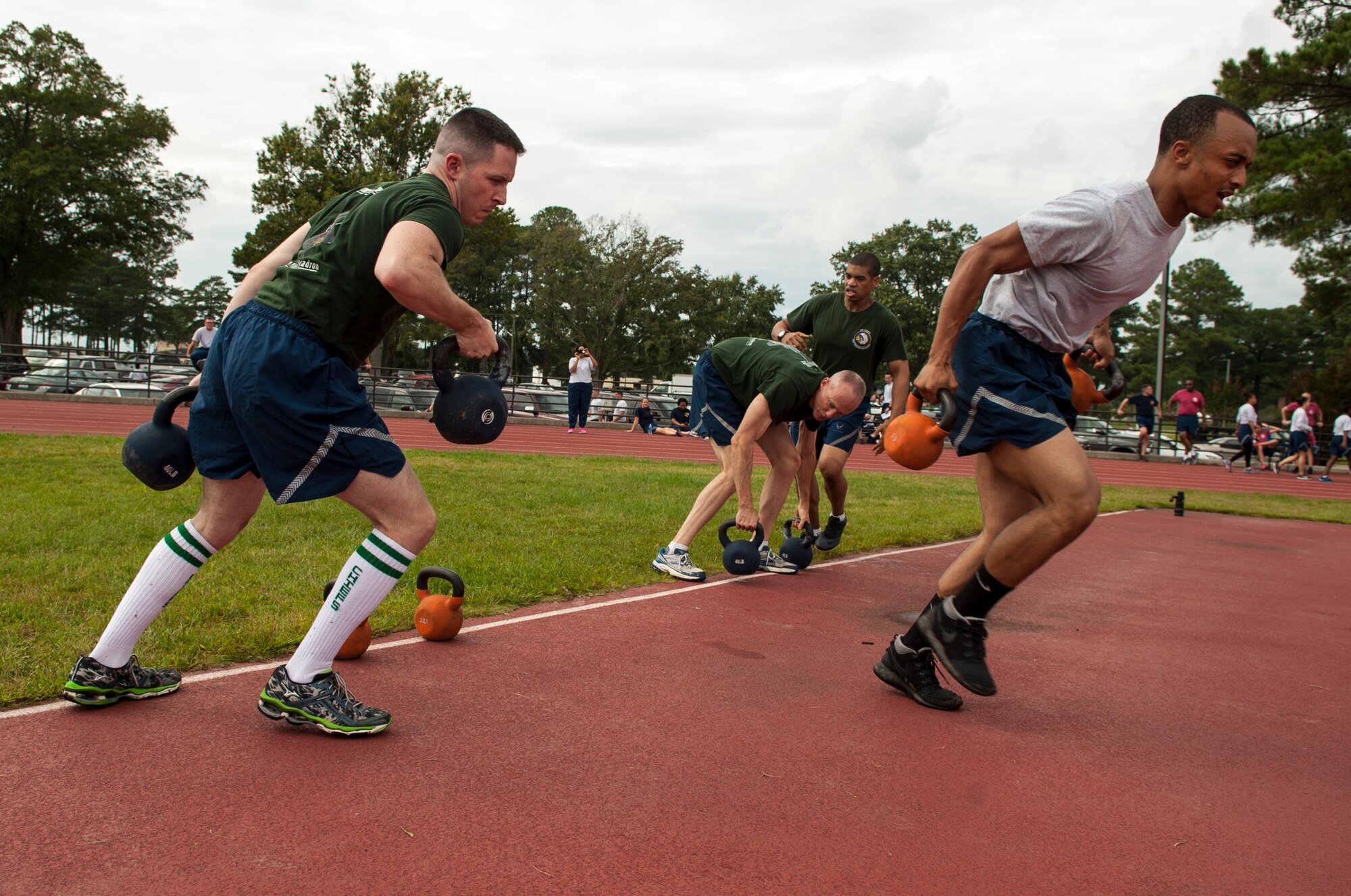 Airmen from the 335th Fighter Squadron race across the track pad with kettle bells during Comprehensive Airman Fitness Day, Sept. 30, 2015, at Seymour Johnson Air Force Base, North Carolina. Teams of four competed in the Commander’s Challenge where they competed for fastest time against other squadrons. (U.S. Air Force photo/Airman Shawna L. Keyes)  