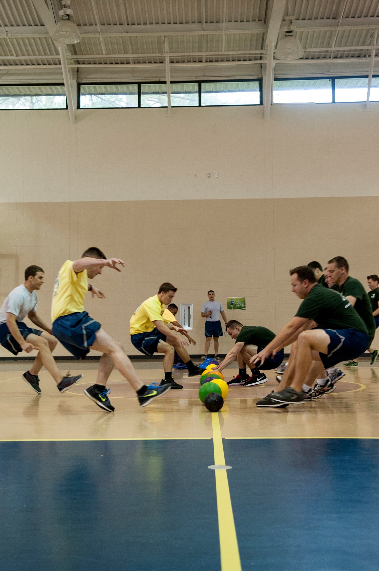 Airmen from the 335th Fighter Squadron and 336th Fighter Squadron, and 4th Aircraft Maintenance Squadron race to the center line to grab dodgeballs during Comprehensive Airman Fitness Day, Sept. 30, 2015, at Seymour Johnson Air Force Base, North Carolina. Airmen competed in teams of eight during the dodgeball tournament, one of several games during CAF Day. (U.S. Air Force photo/Airman Shawna L. Keyes) 