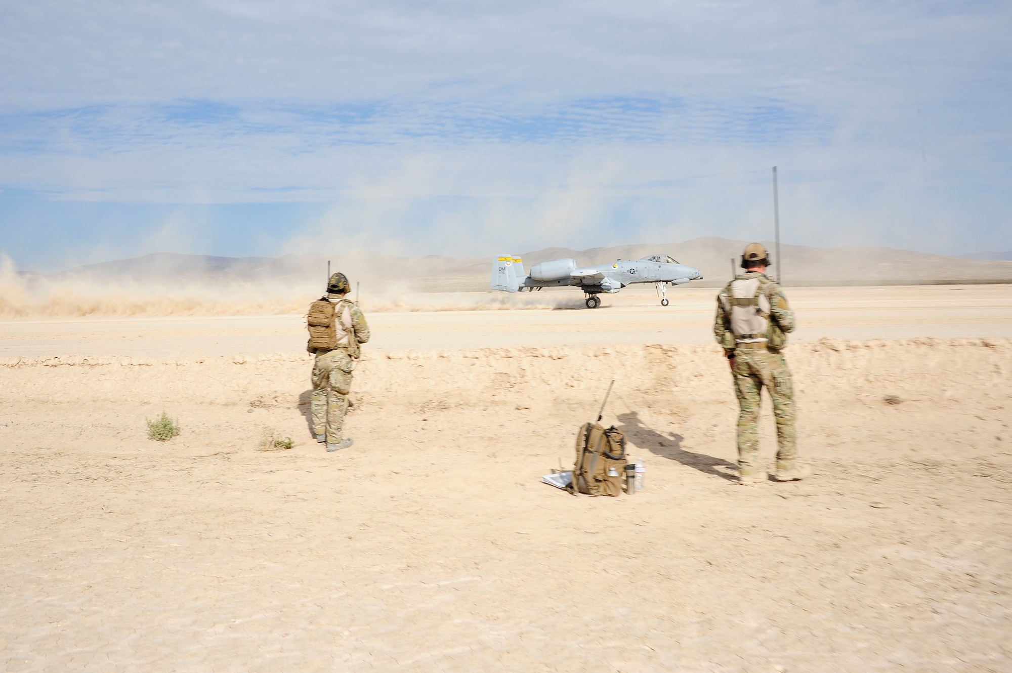 Two U.S. Air Force combat controllers from the 22nd Special Tactics Squadron observe an A-10C Thunderbolt II taking off during austere landing training on Bicycle Lake Army Airfield at the National Training Center range, Fort Irwin, Calif., Sept. 22, 2015. Combat controller’s survey and establish airfields in austere or hostile areas while also providing air traffic control to land aircraft during combat and humanitarian missions. (U.S. Air Force photo by Senior Airman Betty R. Chevalier/Released)