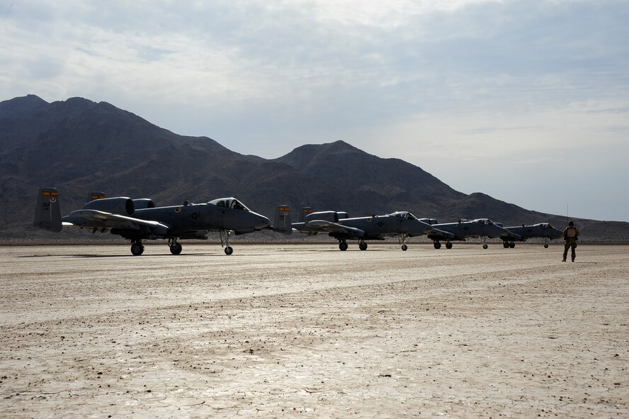 A U.S. Air Force combat controller from the 22nd Special Tactics Squadron communicates with four A-10C Thunderbolt II pilots from the 357th Fighter Squadron on the runway of Bicycle Lake Army Airfield at the National Training Center range, Fort Irwin, Calif., Sept. 22, 2015. A Combat Controller Team assisted the A-10s with austere landings, the landing of an aircraft on an unimproved surface, during Green Flag-West 15-10. Combat controller’s survey and establish airfields in austere or hostile areas while also providing air traffic control to land aircraft during combat and humanitarian missions. (U.S. Air Force photo by Senior Airman Betty R. Chevalier/Released)