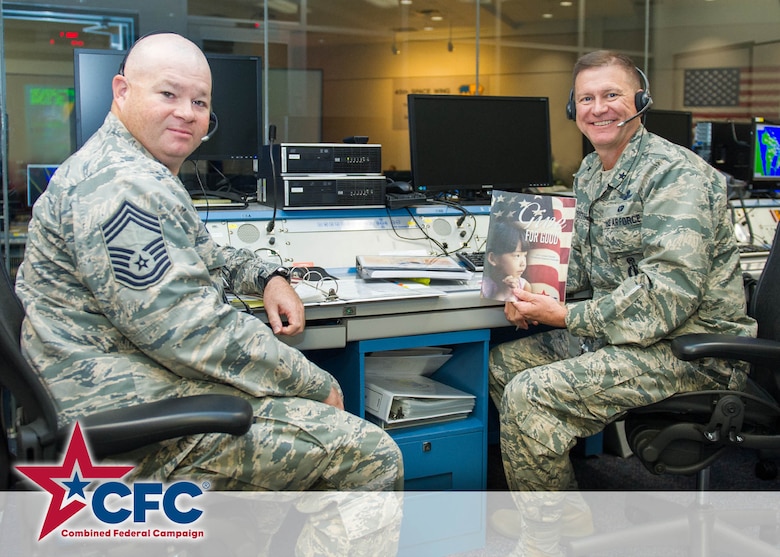 Chief Master Sgt. James A. Isom III, 45th Operations Group chief, and Brig. Gen. Wayne Monteith, 45th Space Wing commander, make a contribution to the Combined Federal Campaign, Oct. 2, 2015, at Cape Canaveral Air Force Station, Fla. This year's CFC theme is 'Give for Good' and kicks-off Oct.1 and runs through Oct. 31. (U.S. Air Force photo/Derwin Oviedo/Released) 