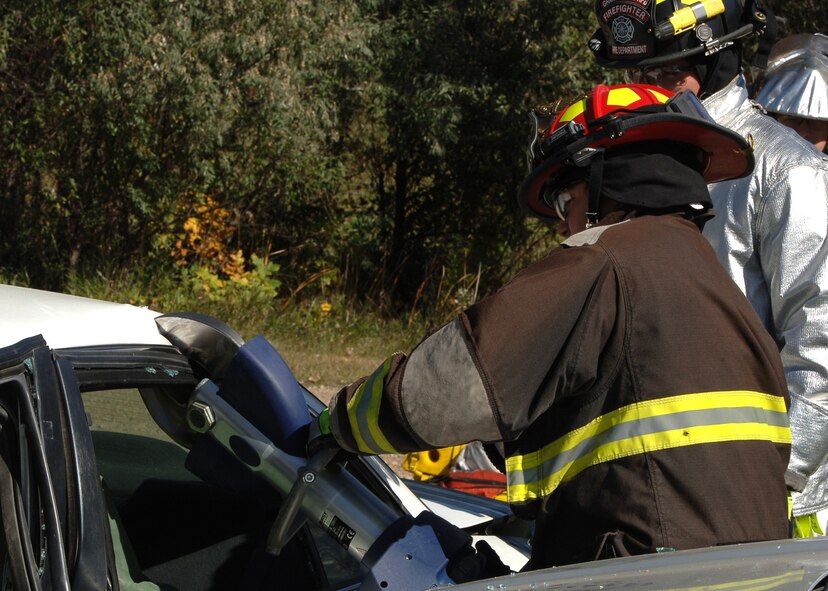 Marcus Carpenter, 319th Civil Engineer Squadron lead firefighter, cuts through a roof of a car using the Jaws of Life during an auto extrication exercise Sept. 29, 2015, on Grand Forks Air force Base, North Dakota. Carpenter teaches Airmen how to operate the Jaws of Life to remove a simulated victim from a wrecked vehicle. (U.S. Air Force photo by Airman 1st Class Ryan Sparks/Released)