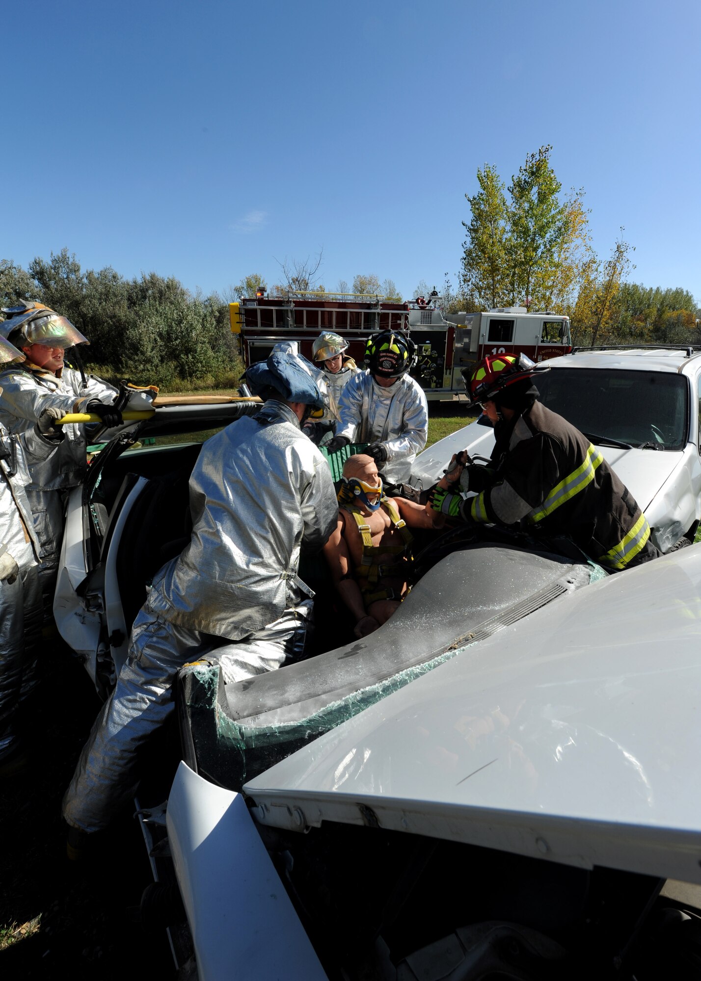 Airmen from the 319th Civil Engineer Squadron Fire Department, prepare to remove a simulated victim from a car during an auto extrication exercise Sept. 29, 2015, on Grand Forks Air Force Base, North Dakota. The Grand Forks AFB Fire Department performed vehicle extrication tactics as part of their required training. (U.S. Air Force photo by Airman 1st Class Ryan Sparks/Released)