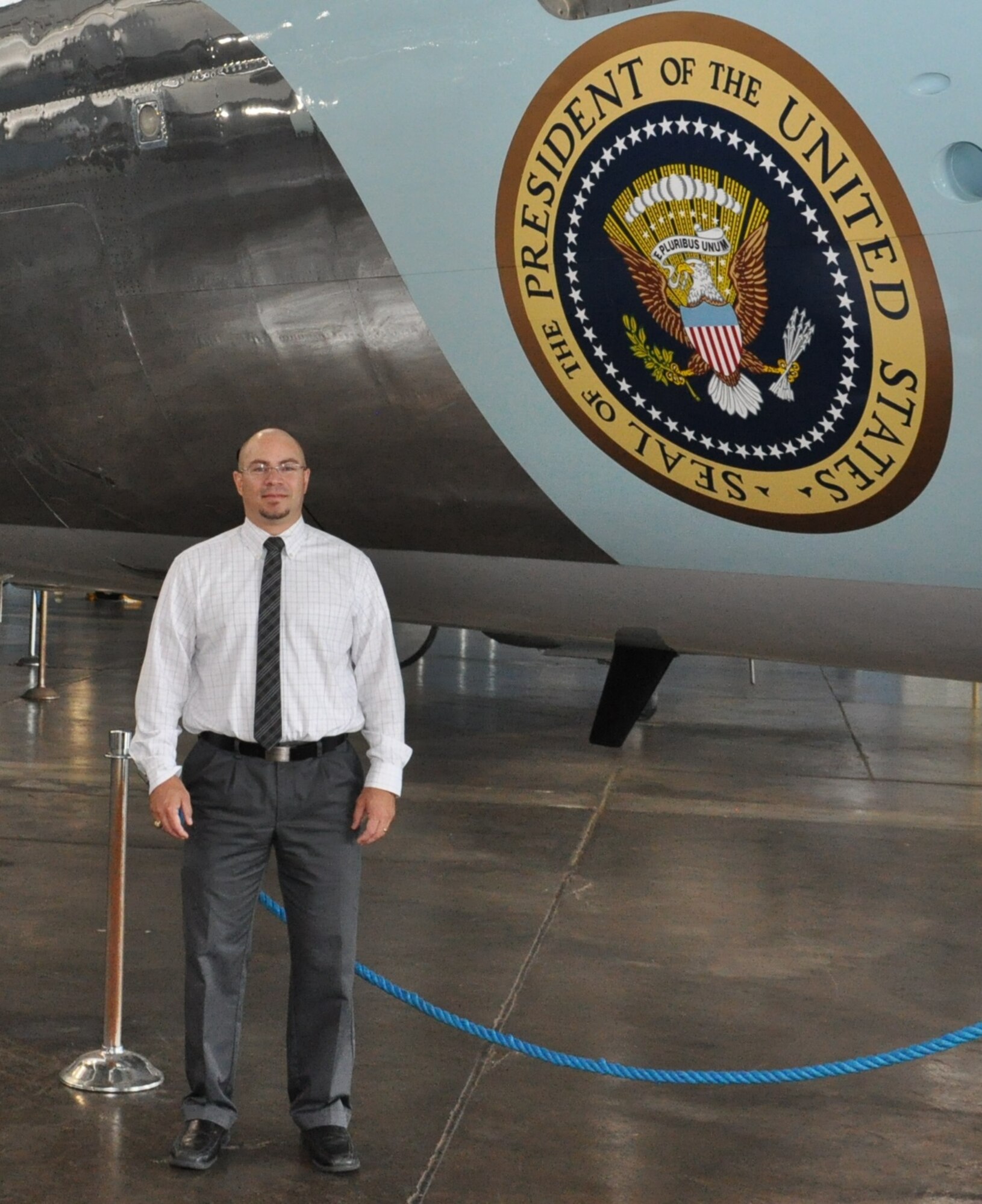 Edgardo Santiago-Maldonado stands in front of a former presidential aircraft located at the National Museum of the United States Air Force. (U.S. Air Force photo/Bryan Ripple)