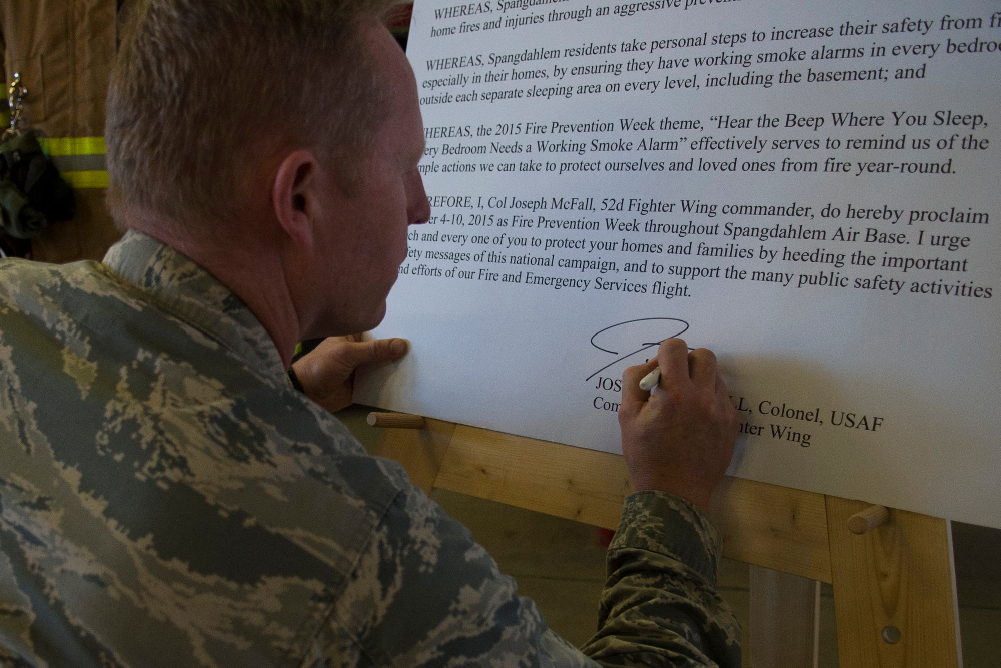 U.S. Air Force Col. Joe McFall, 52nd Fighter Wing commander, signs a proclamation declaring Oct. 4-10 as Fire Prevention Week during a proclamation signing at Fire House 1 on Spangdahlem Air Base, Germany, Oct. 2, 2015. Every year, Spangdahlem observes Fire Prevention Week with this year’s theme being, 'Hear the beep where you sleep, every bedroom needs a working smoke alarm.' (U.S. Air Force photo by Airman 1st Class Luke Kitterman/Released)